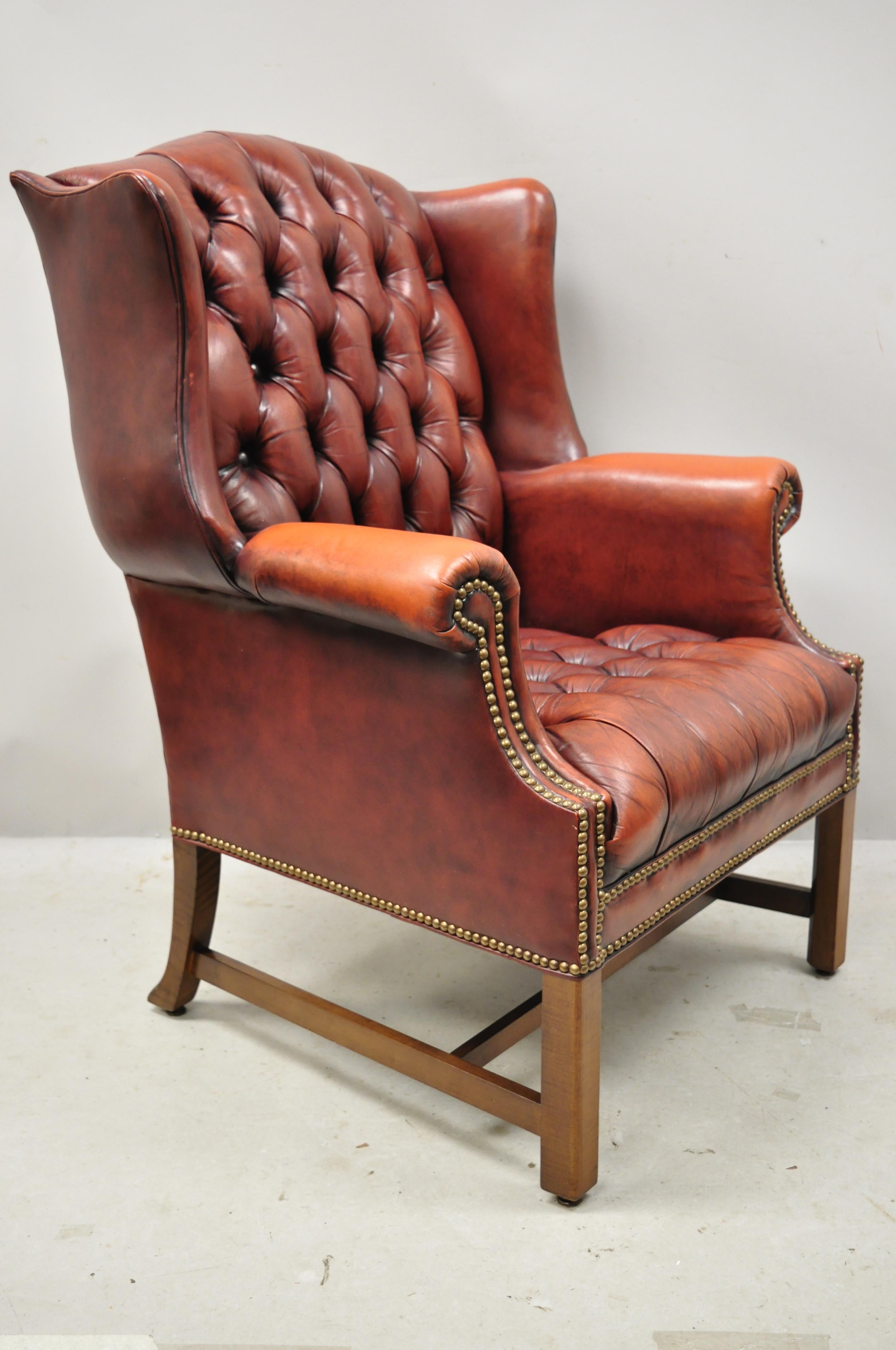 Vintage English Chesterfield style button tufted burgundy leather wingback chair. Item features button tufted leather upholstery, nailhead trim, remarkable patina, rolled arms, solid wood frame, distressed finish, quality American craftsmanship,