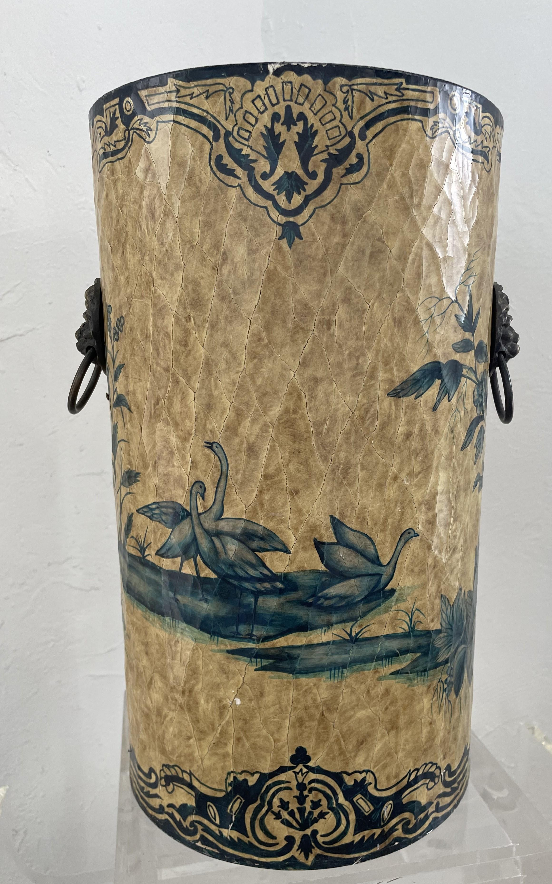This sturdy and elegant English-chinoiserie umbrella stand gets its sturdiness from its metal core and its elegances from the hand painted chinoiserie nature scene on papier mâché in gold and green. A combination that provides a utilitarian