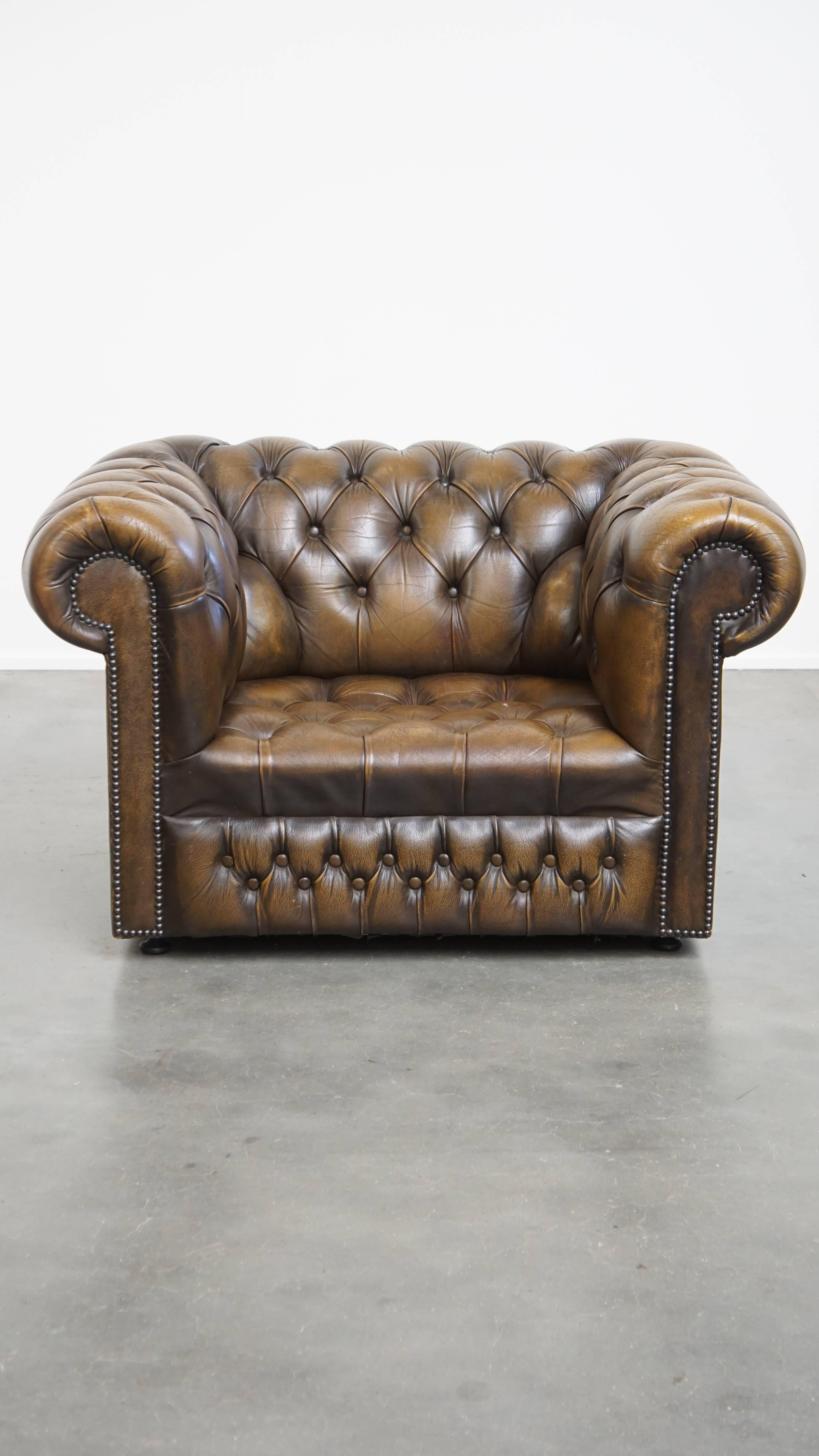 Offered here is this beautiful vintage English cowhide leather Chesterfield button seat armchair.

Thanks to its stunning color, this magnificent cowhide Chesterfield armchair is a true eye-catcher in almost any interior or space. It exudes the