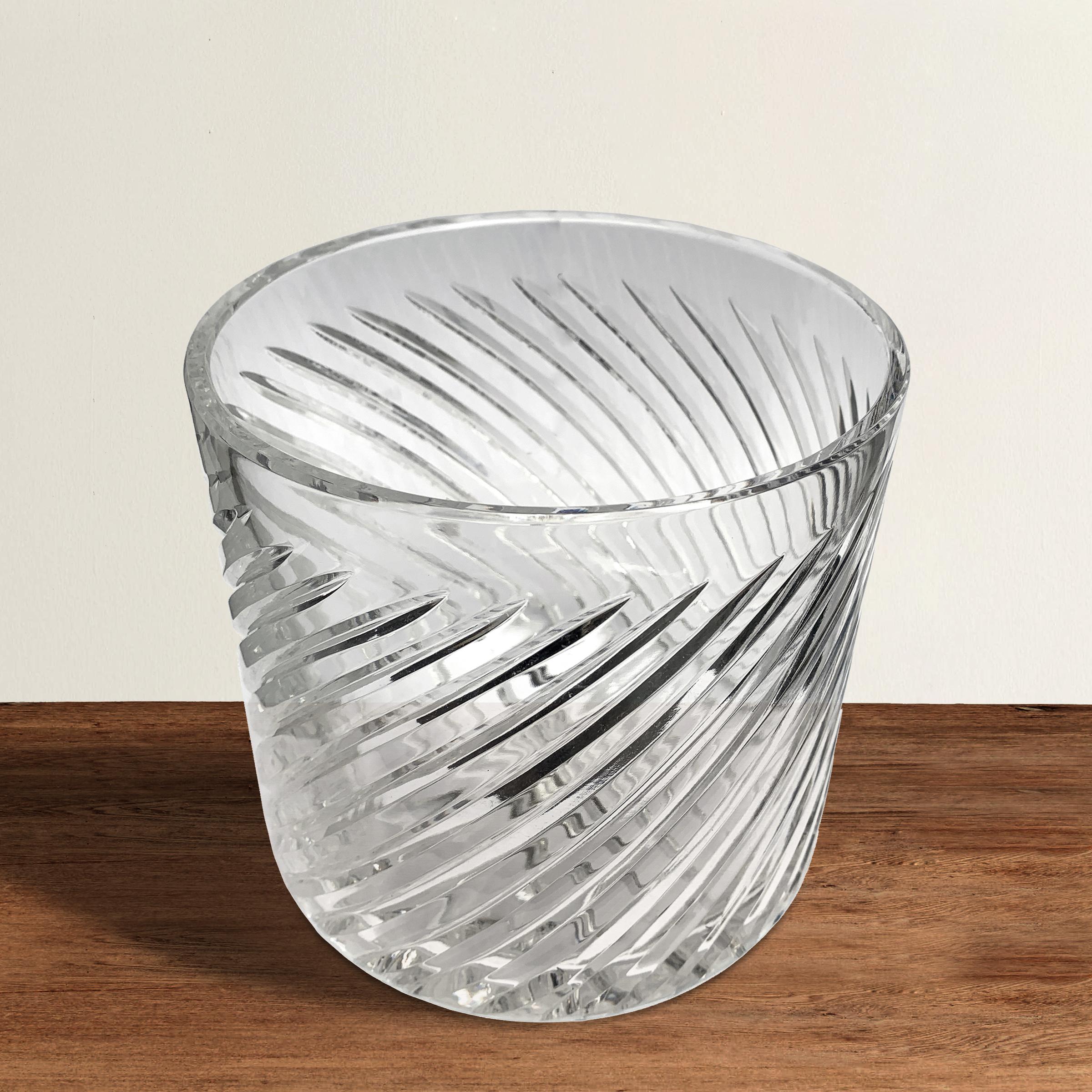 A vintage English heavy crystal ice bucket with a swirled pattern on the sides and a star on the bottom, all wheel-cut by hand, by a master cutter.