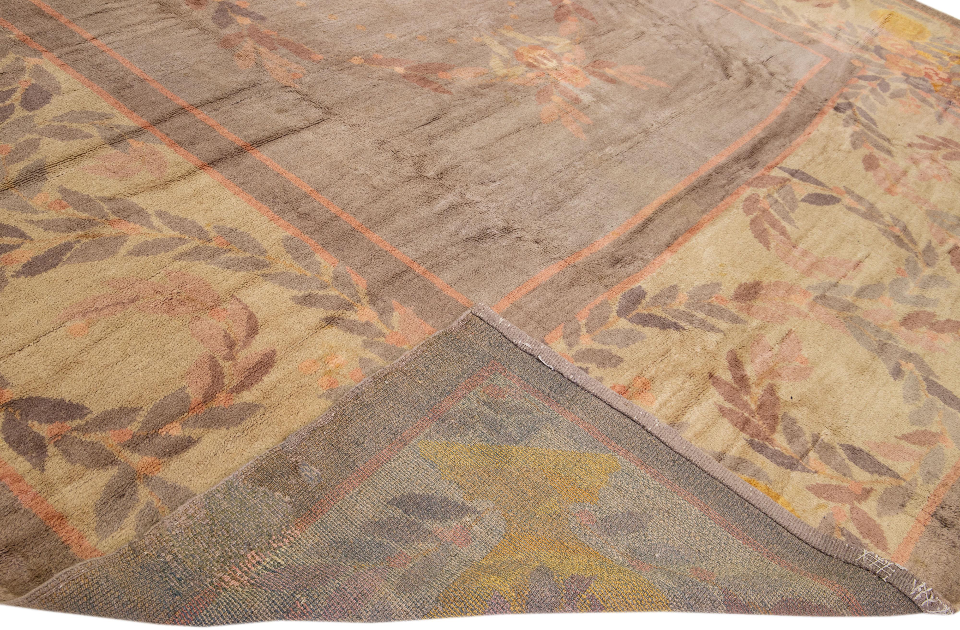 Magnifique tapis vintage anglais Donegal en laine nouée à la main avec un champ de couleur grise. Cette pièce a un cadre de couleur beige avec des accents pêche, jaune et gris dans un motif de vignes feuillues.


Ce tapis mesure : 14'9