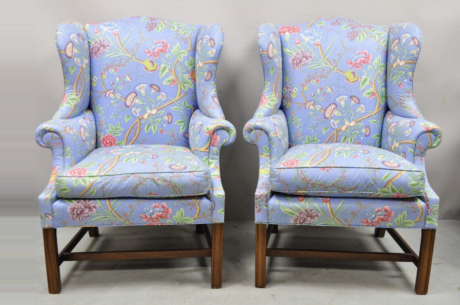 Vintage English Edwardian style mahogany blue floral wingback chairs - a pair. Item features shapely rolled arms and winged backs, blue floral print upholstery, stretcher base, solid wood frames, quality American craftsmanship, great style and form.