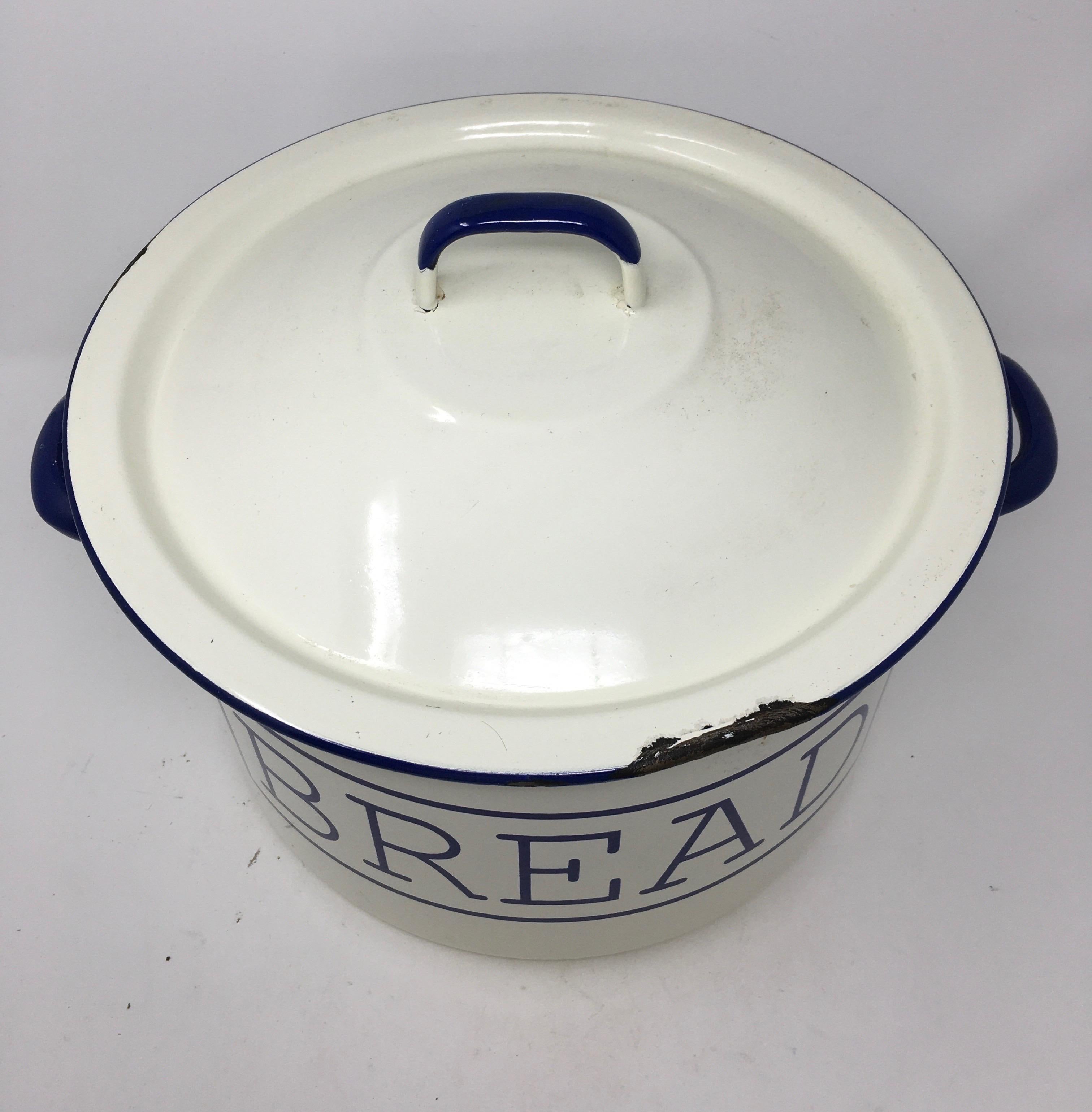 Found in England, this is an enamel bread bin with lid. Once used to store bread this piece will now add English charm to your kitchen. The white enamel is accented with blue lettering and handles.
