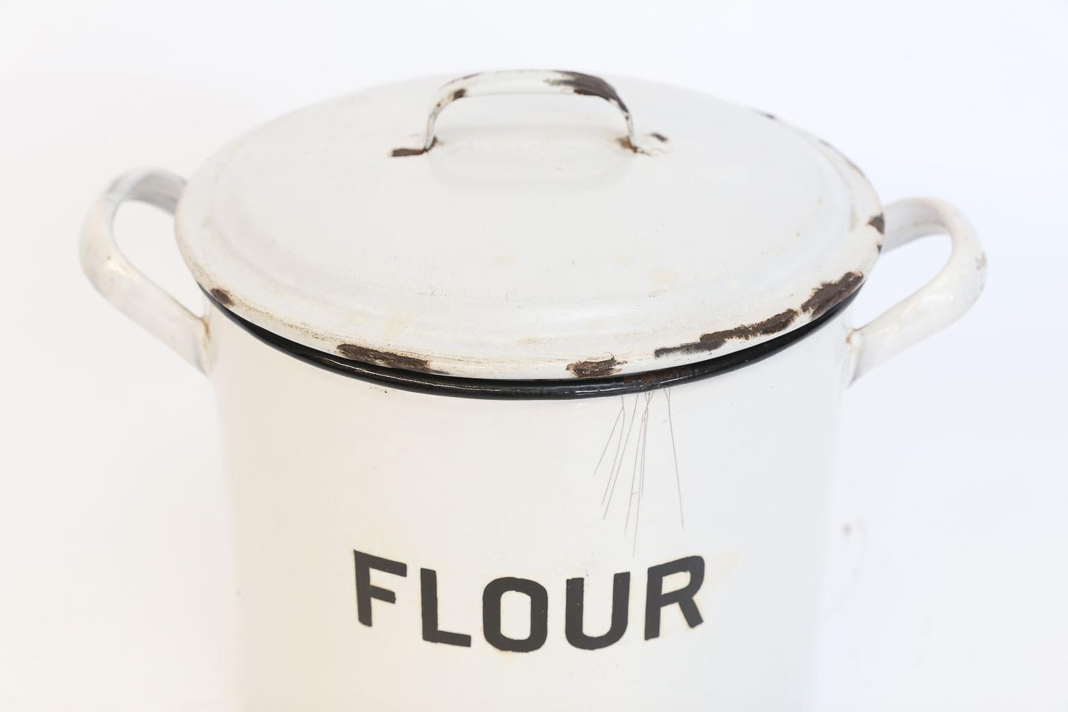 Found in England, this is an enamel flour bin with lid. Once used to store flour, this piece will now add English charm to your kitchen. The white enamel is accented with black lettering.
