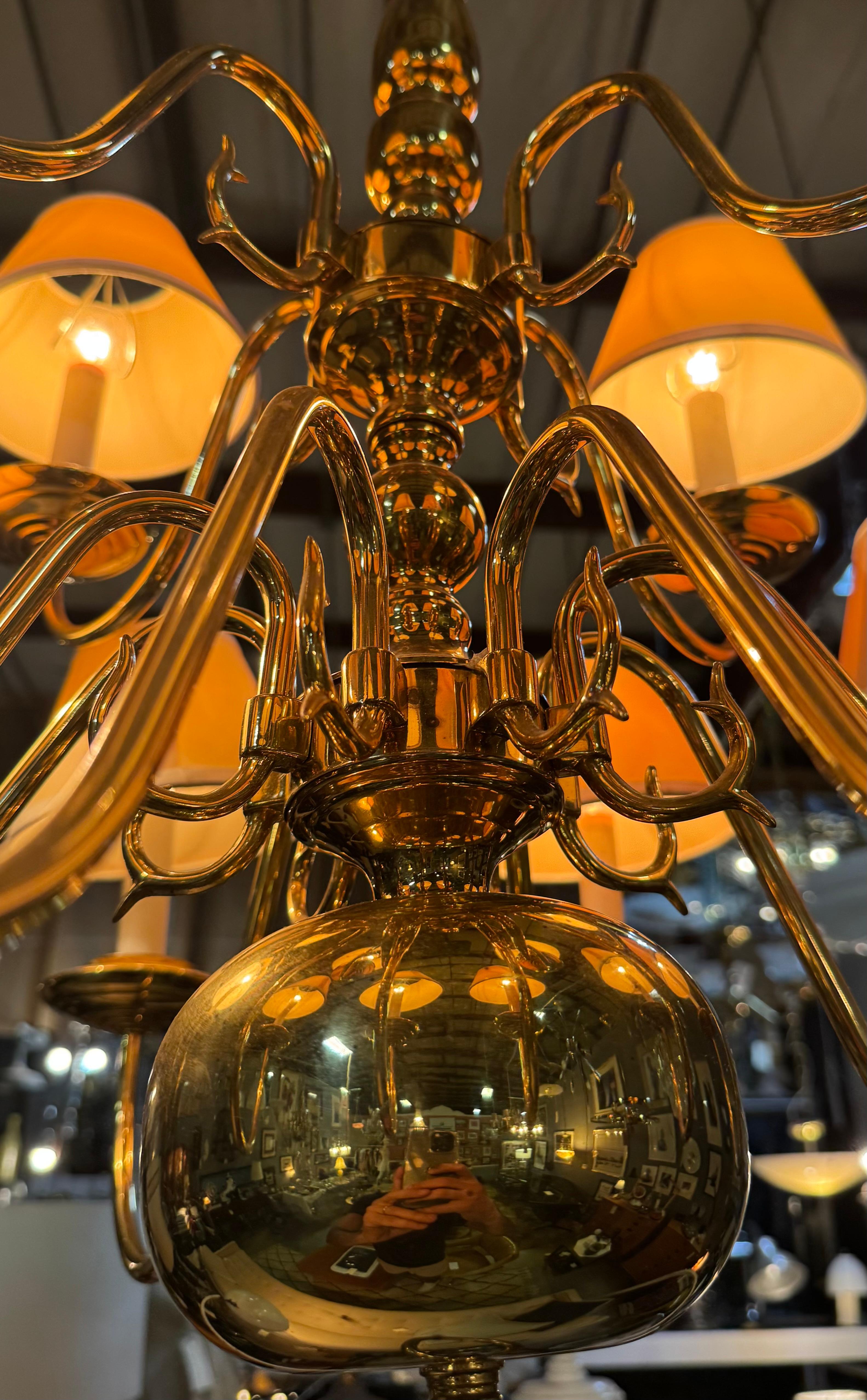 Grande stile georgiano
lampadario con 12 (dodici) bracci elettrificati, in ottone lucido.

Presenta elementi classici del design inglese, tra cui la forma a urna del palo e il grande globo sottostante, mentre ogni braccio a voluta curvilinea culmina