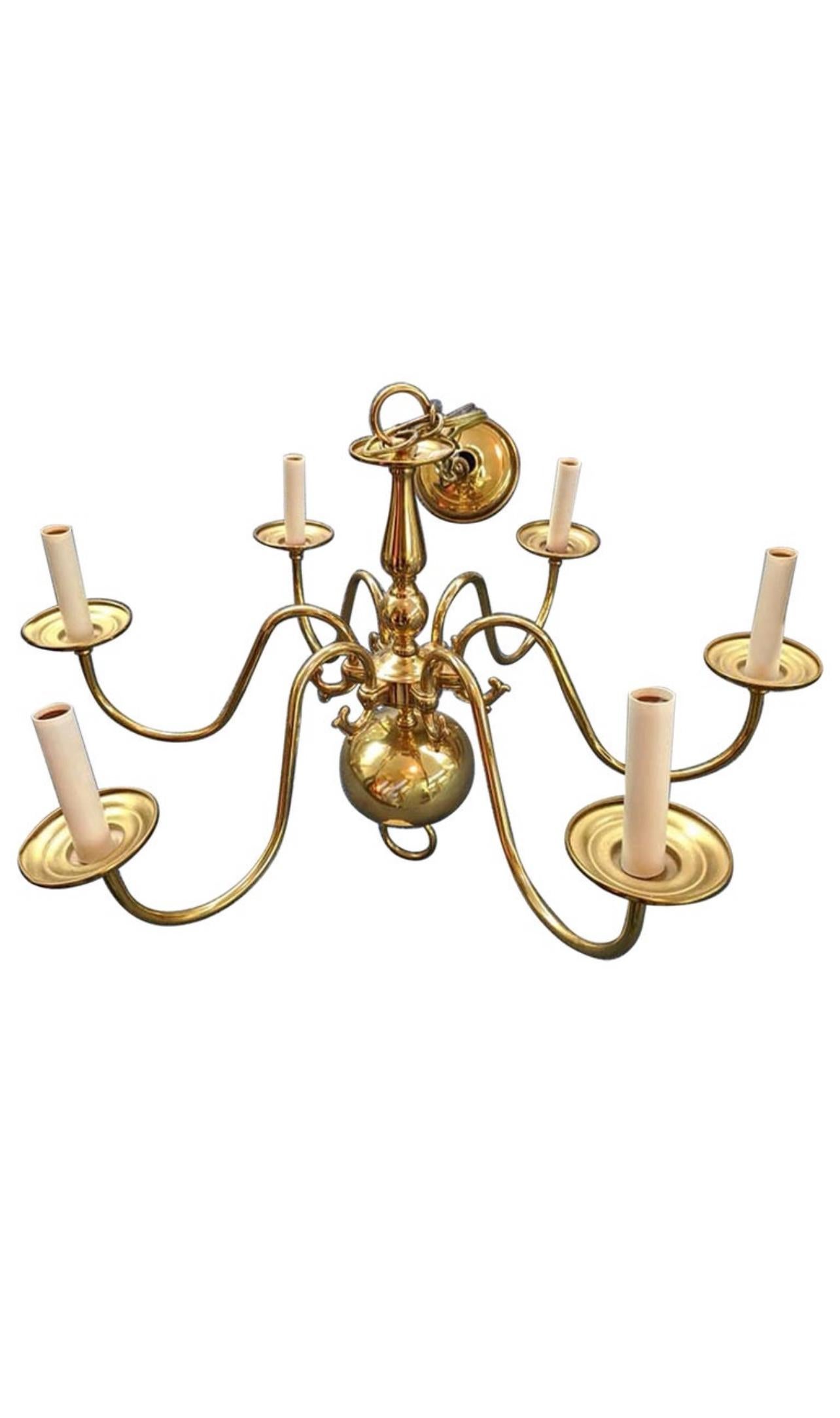Georgian-style medium
size chandelier with six (6) electrified arms, in polished brass.

Features classic English design elements including urn shape in the post and large globe below, with each curved scroll arm culminating in a thick candle cup