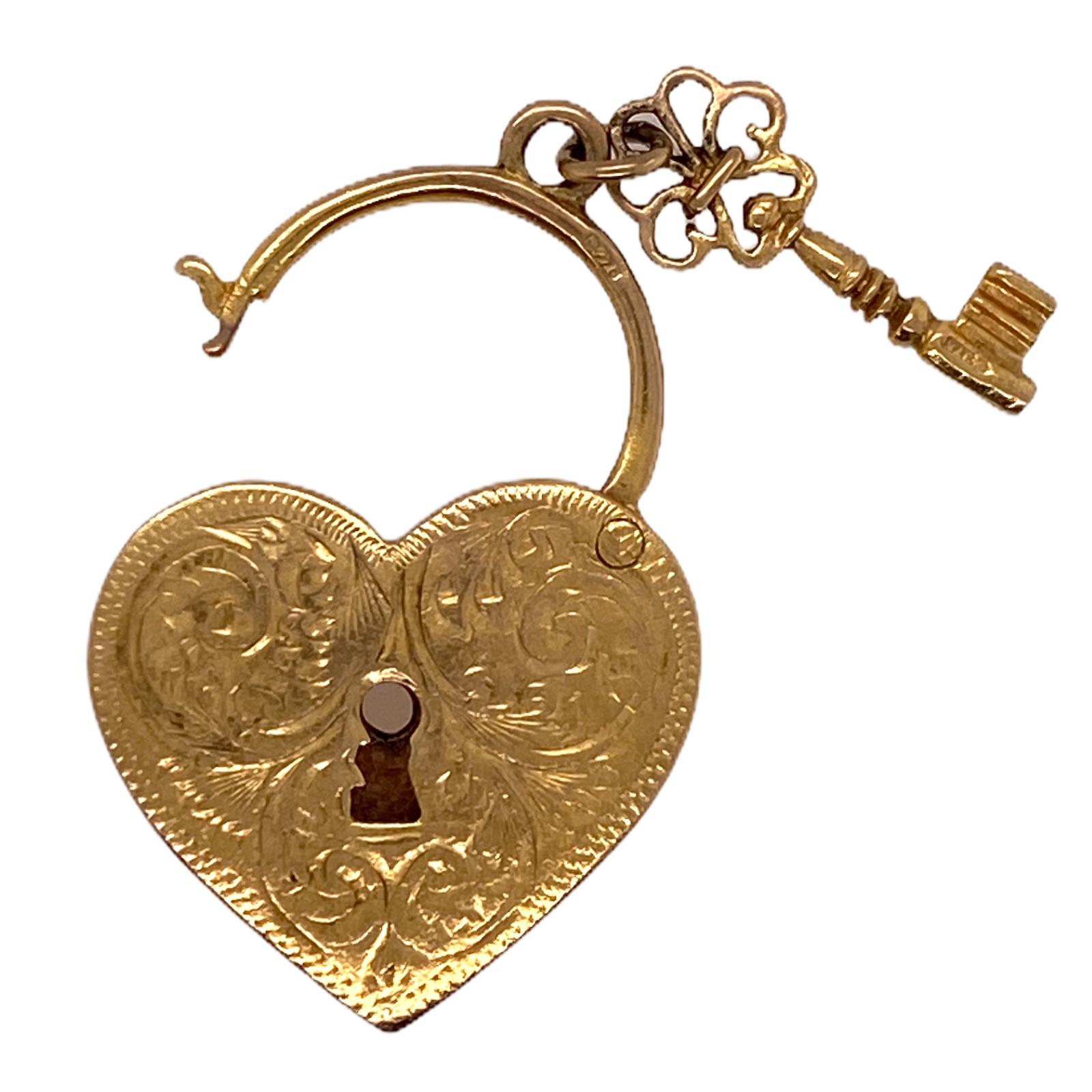 Original vintage heart lock and key charm fashioned in 9 karat yellow gold. The English made charm opens & closes, and measures 1.0 x 1.25 inches. European hallmarks. 