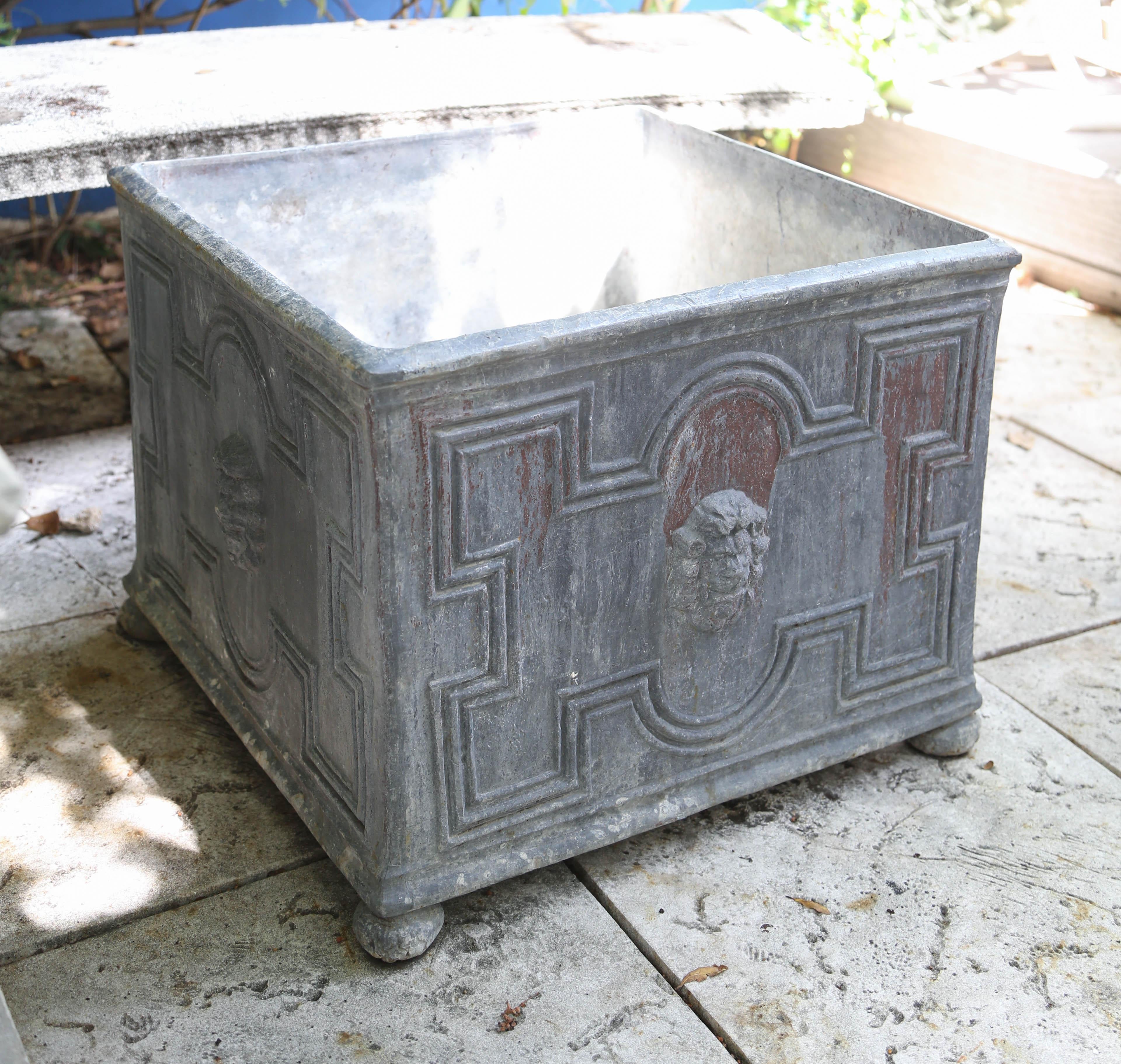 Large square vintage lead planter with lion heads on all sides.