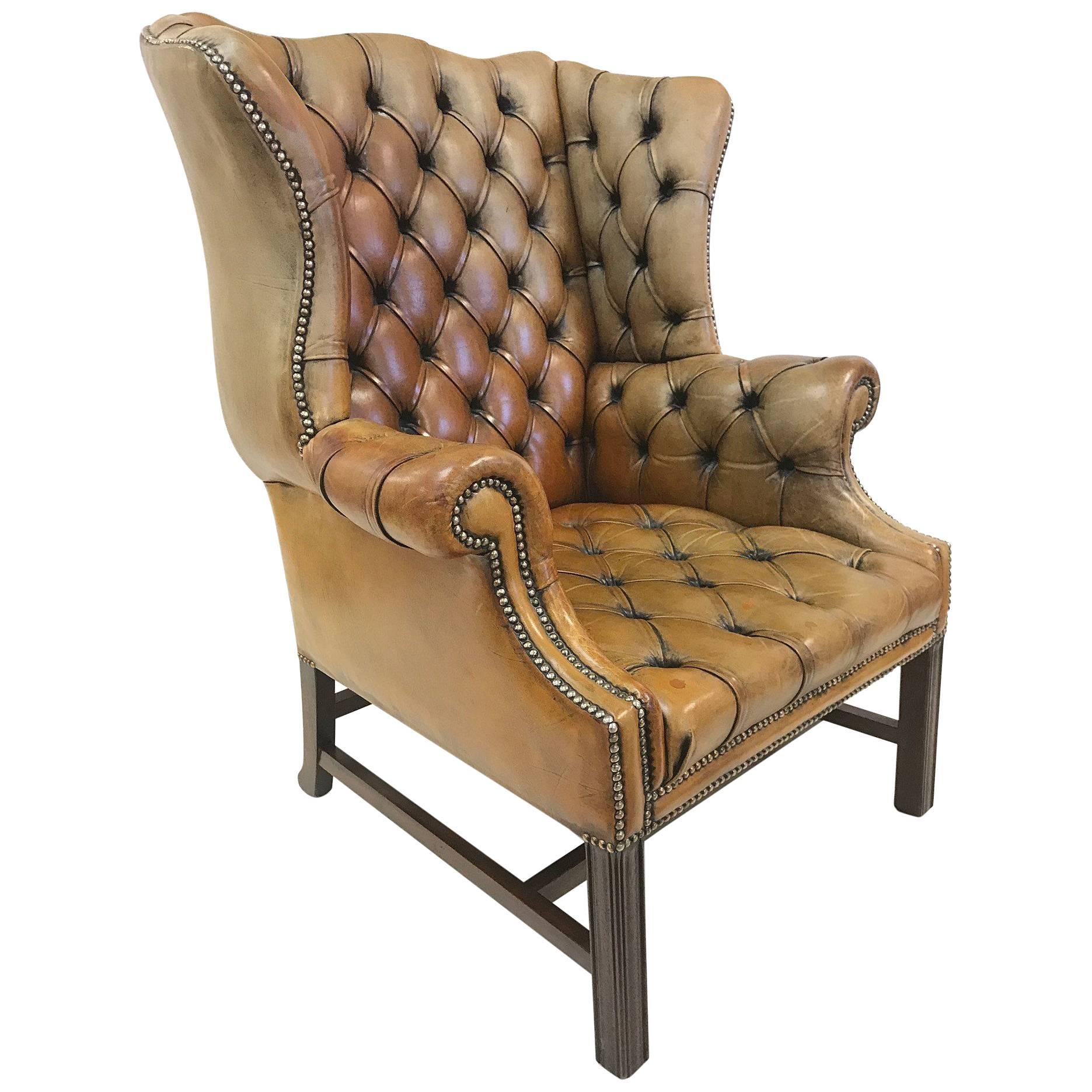 Vintage leather tufted wingback library chair. Has a solid walnut base.