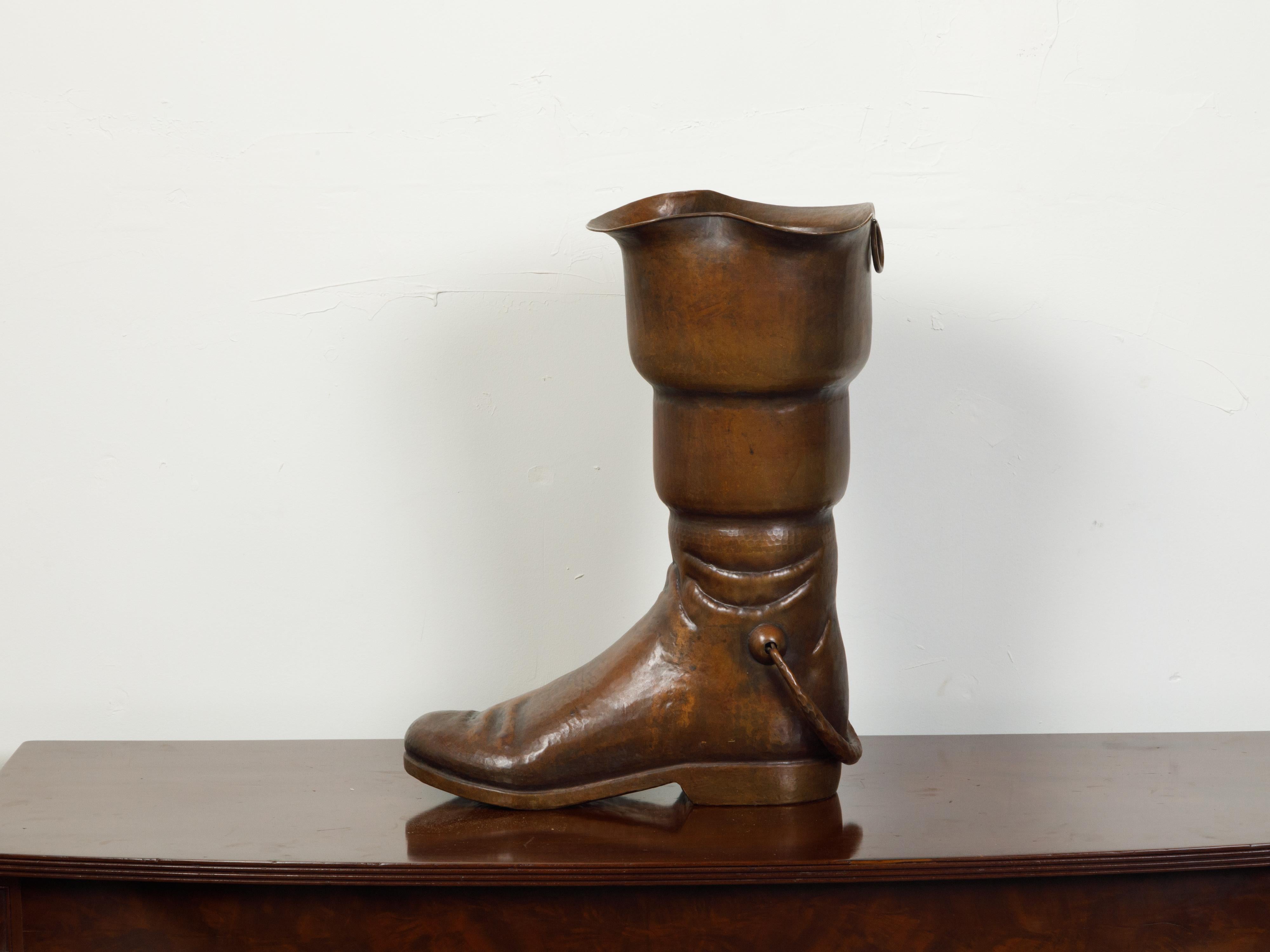 An English copper umbrella stand from the mid 20th century, depicting a boot. Created in England during the Midcentury period, this copper umbrella stand features a copper boot pierced in its center to place umbrellas in it. A charming addition to