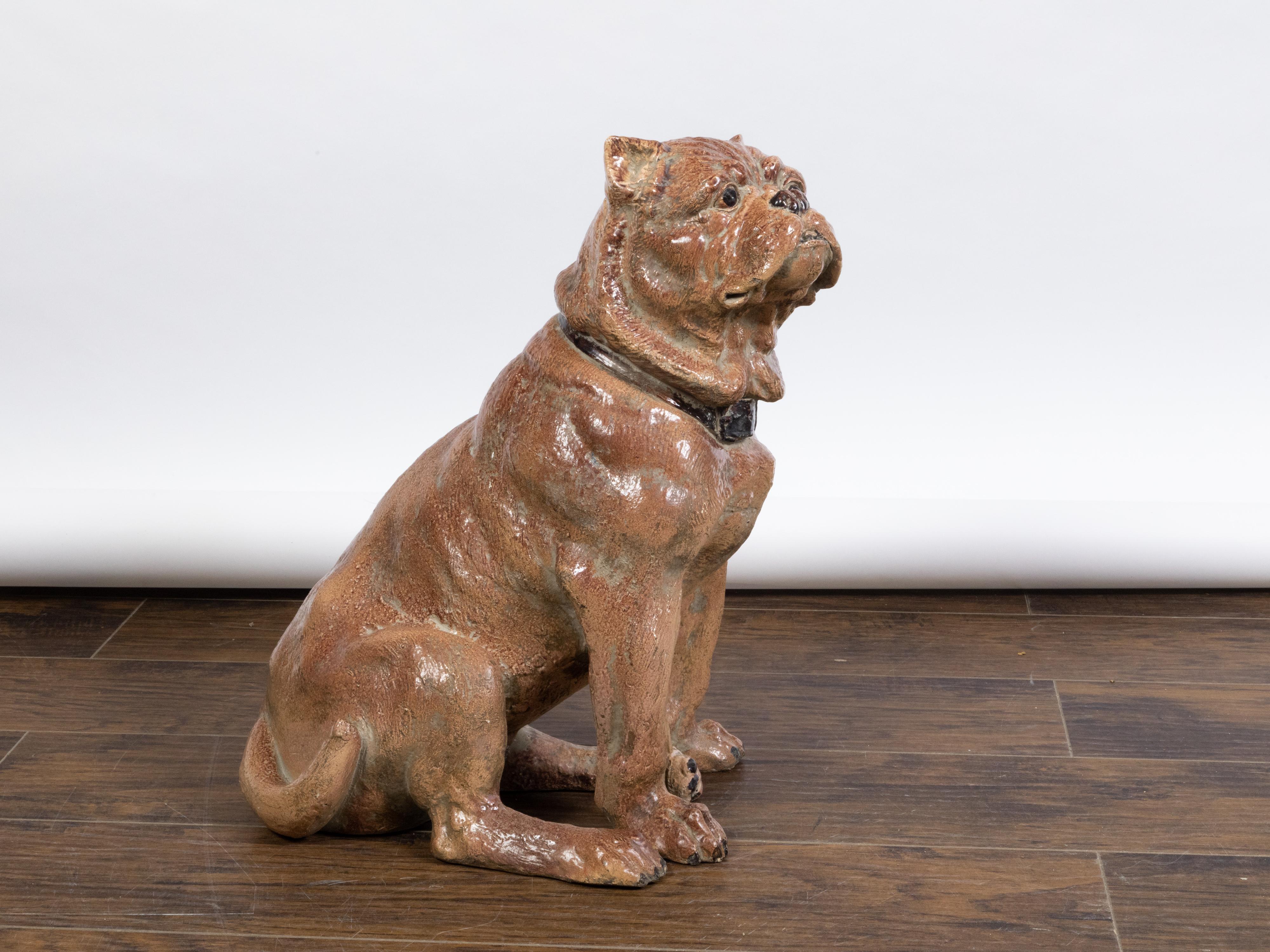 An English vintage pottery bulldog statue from the mid 20th century, with black collar. Created in England during the midcentury period, this statue depicts a brown hair bulldog seating obediently, his tail tucked to the side. Showcasing a stern