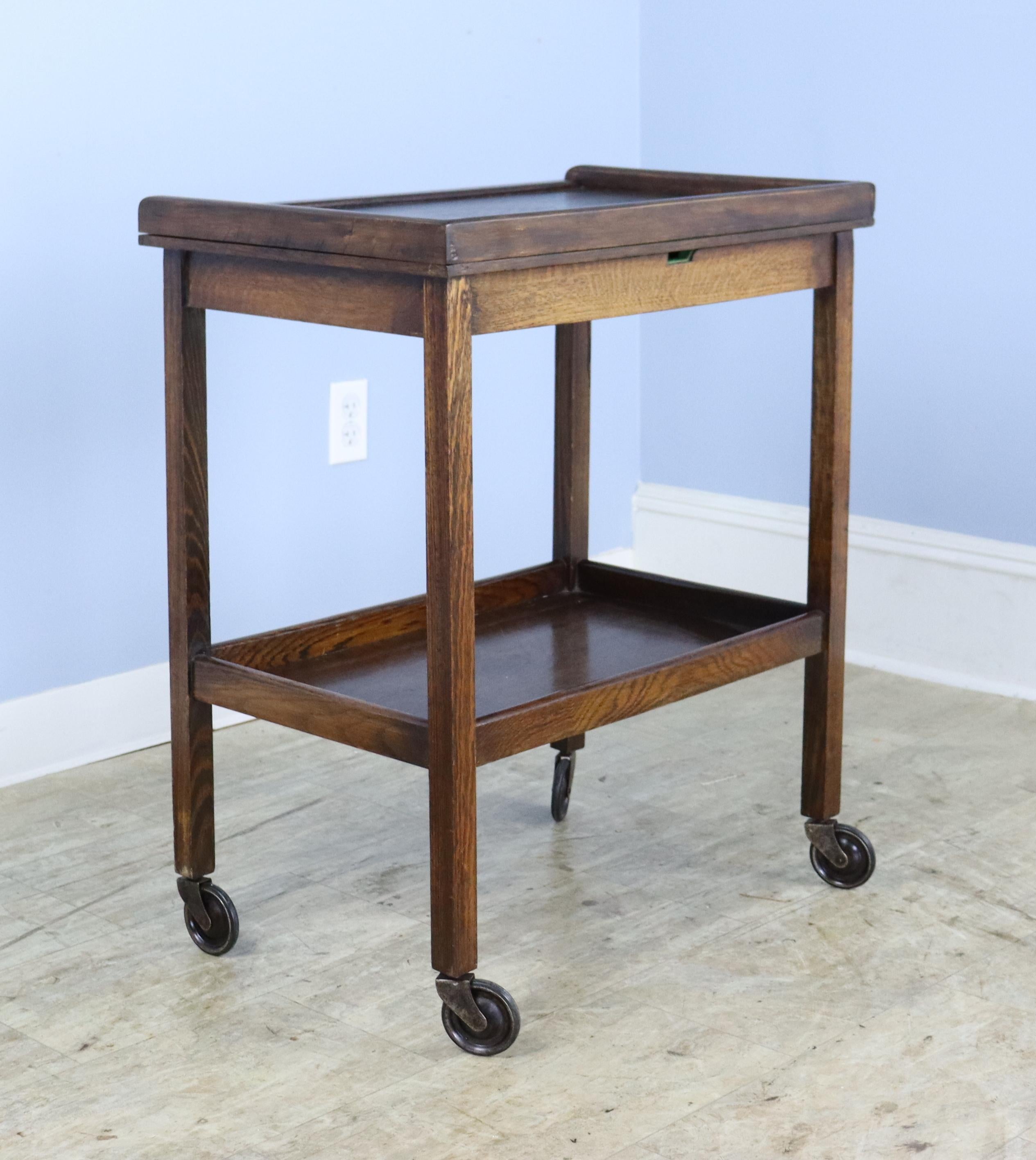 A charming side table in rich oak that converts into a larger games table.  The swivel mechanism is very easy to use, and the transformation from side table to games table takes only seconds.  The original green felt is in very good vintage