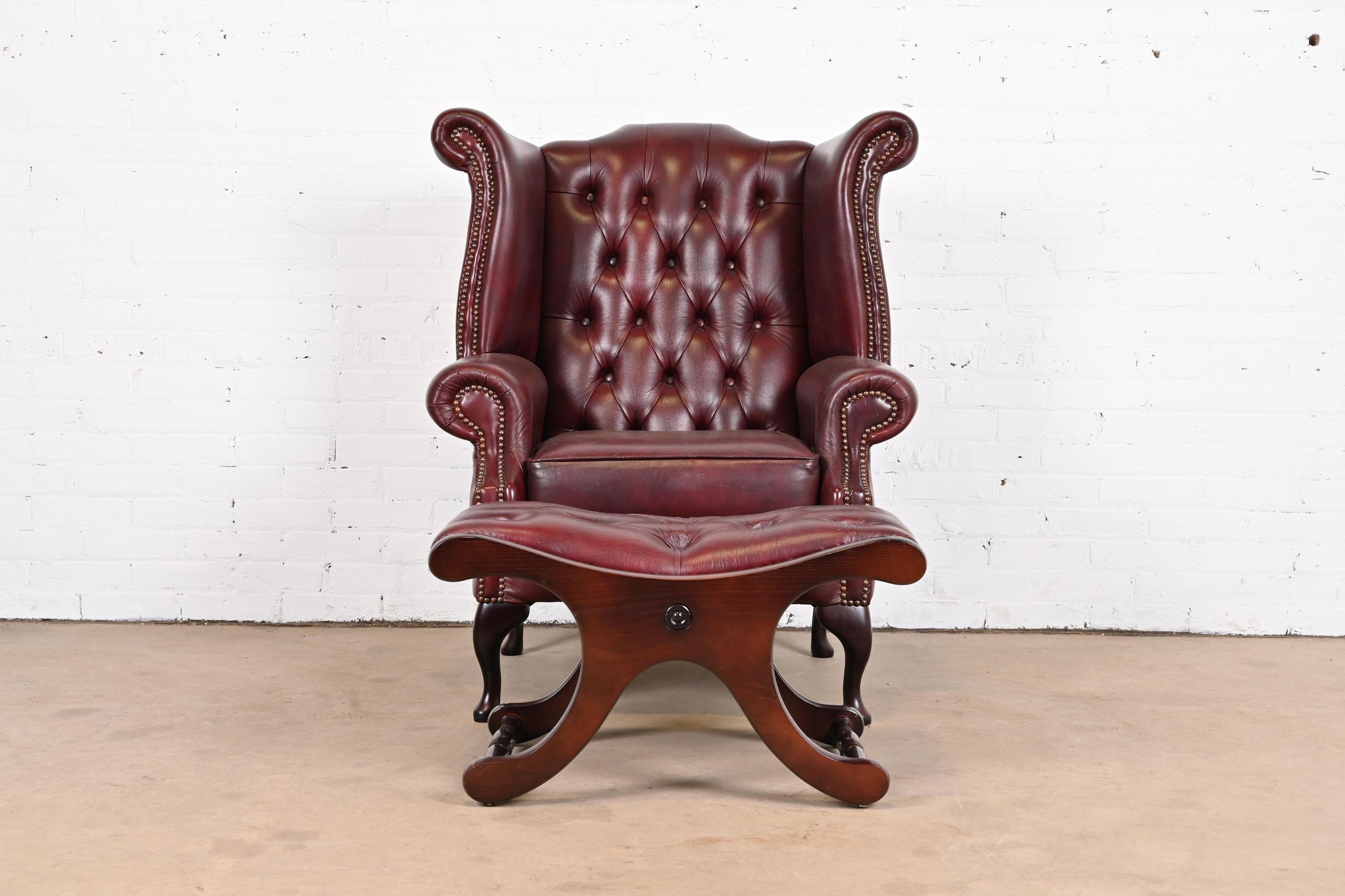 A gorgeous vintage Chesterfield wingback lounge chair with ottoman

England, Circa late 20th century

Tufted oxblood leather, with brass studs and mahogany legs.

Measures:
Chair: 35.5