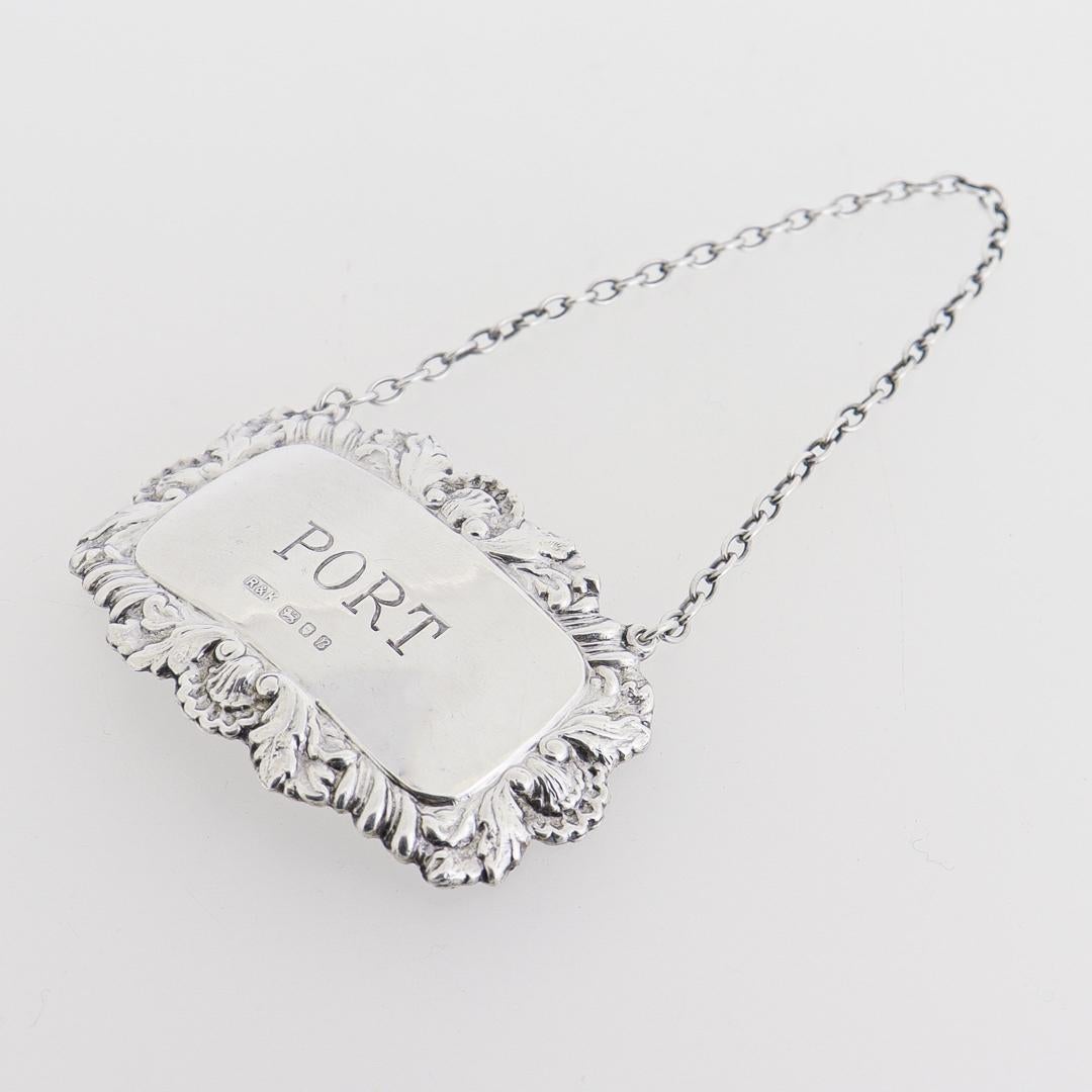 A fine vintage English Port decanter or liquor label.

In sterling silver.

By Richards & Knight. 

The octagonal silver label hangs on a chain and reads: PORT

Marked with English hallmarks for Richards & Knight, Birmingham, Sterling, 1976.