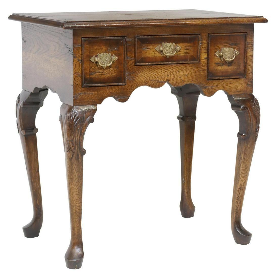 Vintage English Queen Anne style oak lowboy/ hall table, 20th c. This table features three drawers, with batwing pulls, over scalloped apron, rising on foliate carved cabriole legs, ending on pad feet.

Dimensions 
approx 28.75