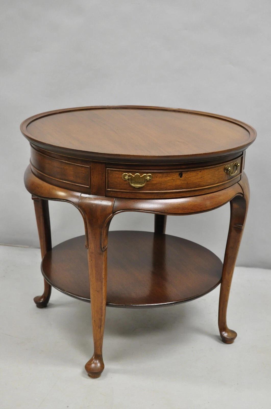 Vintage English Queen Anne Style Solid Round Walnut Wood Lamp Side Table with Single Dovetailed Drawer by Hekman. Circa Late 20th Century. Measurements: 24.5