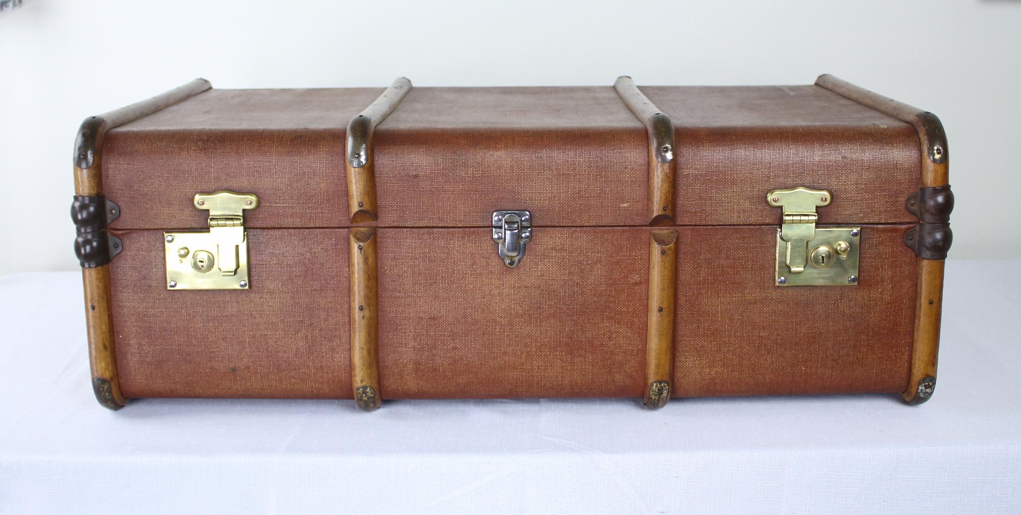 Built to withstand the challenges of long distance travel, this vintage brown steamer trunk is a British design Classic. Whether you are introducing this unique piece in your home as a coffee table or to add vintage style to a room, this travel
