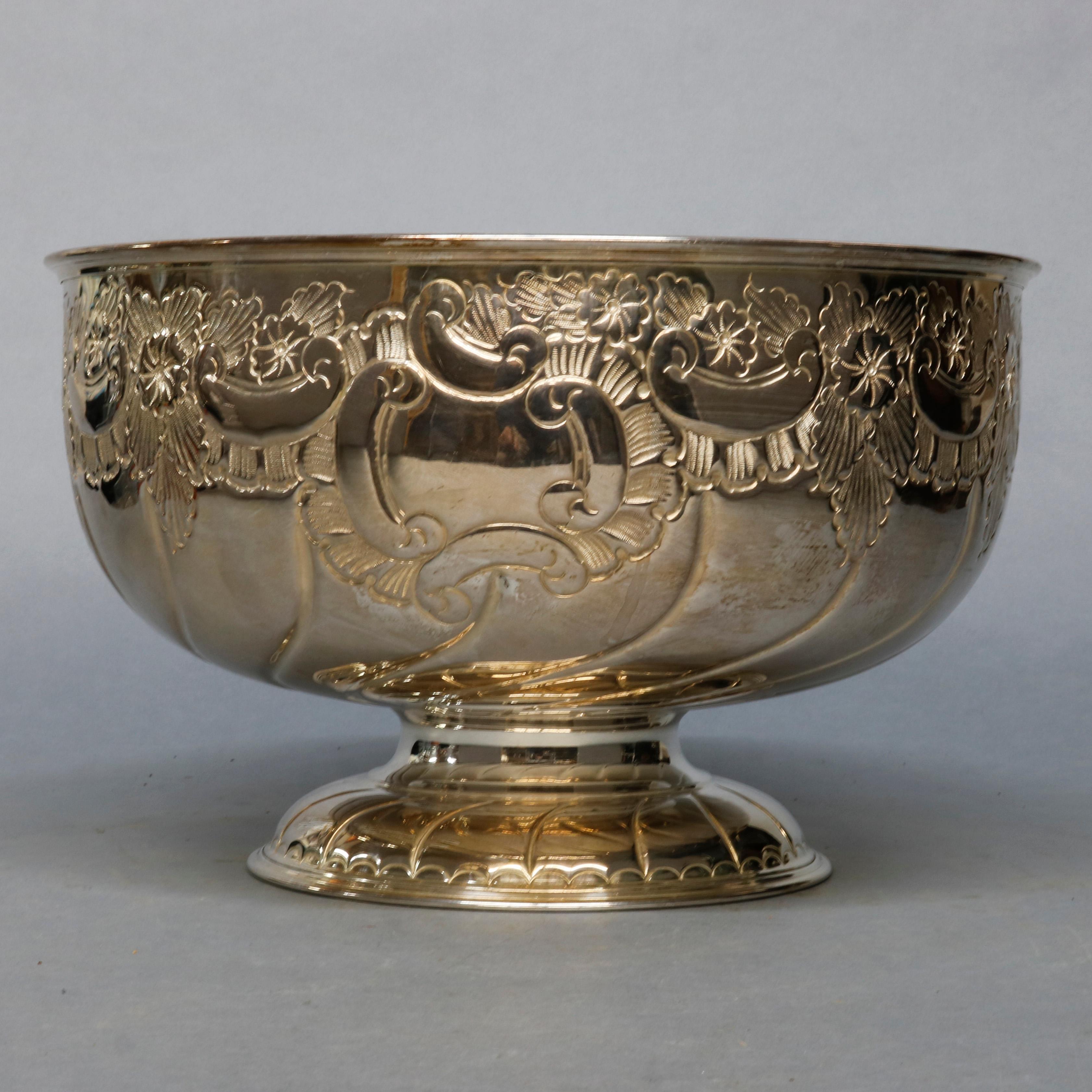 A vintage English Sheffield punch bowl offers silver plate construction with melon twist bowl having floral repousse collar and raised on flared foot, maker mark on base as photographed, circa 1930.

Measures: 9