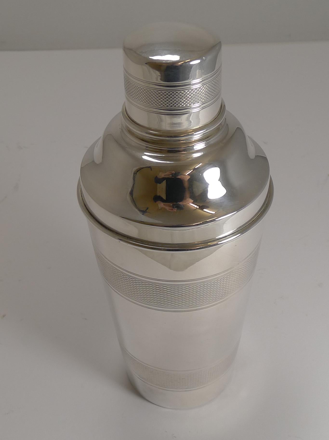 A smart English Art Deco cocktail shaker with highly sought-after engine turned decoration.

The underside is signed by the silversmith, P.H. Vogel and Co. (Warstone Parade, Birmingham) and struck 