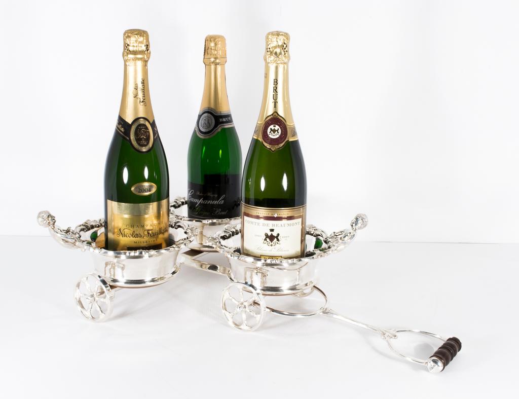 This is a superb vintage English silver plated triple bottle coaster dating from the early 20th century.

It is ornately fashioned in the form of a triple cart and is appropriate for both champagne and wine bottles.

Add an elegant touch to your