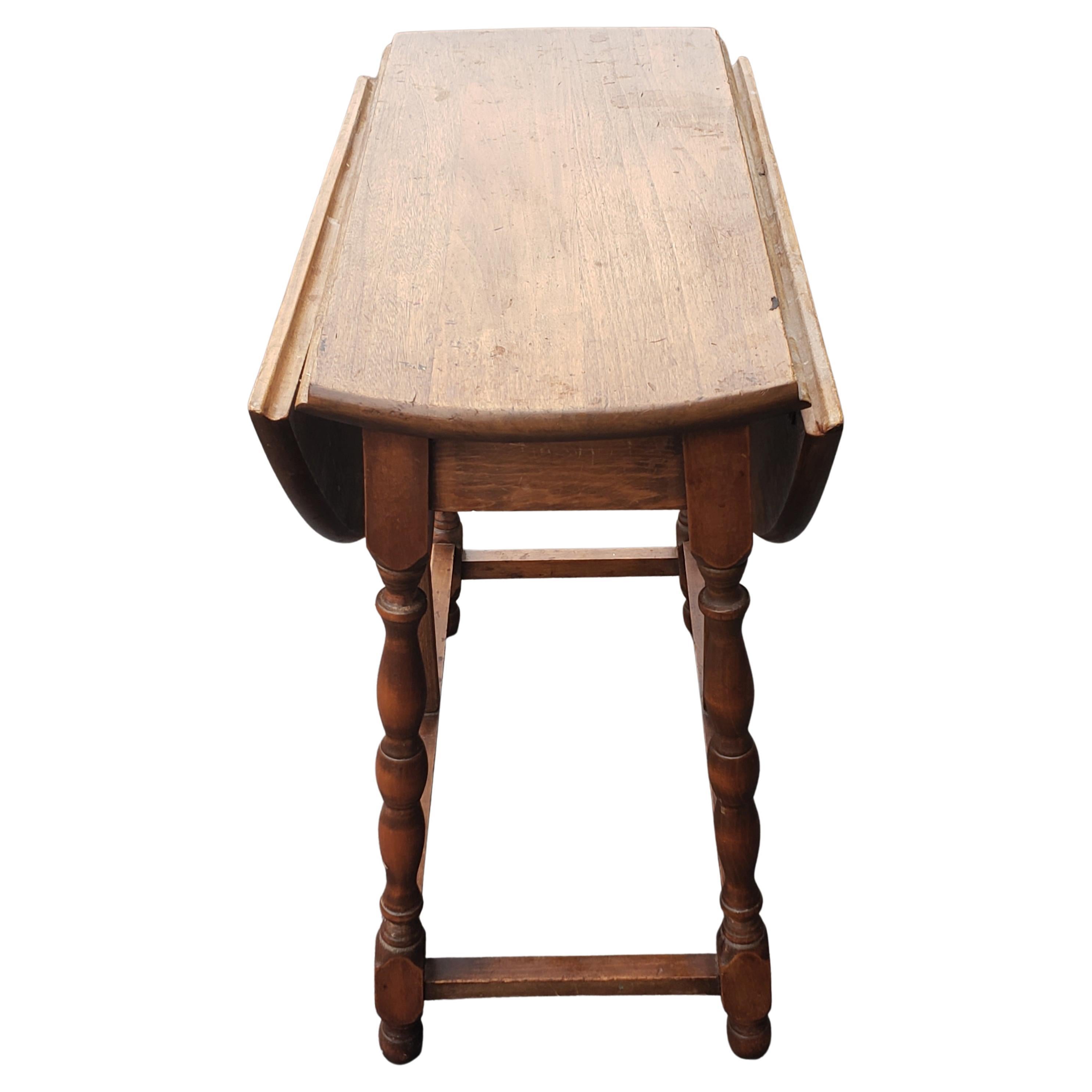 Vintage English solid oak drop leaf side table.
Measures: 25