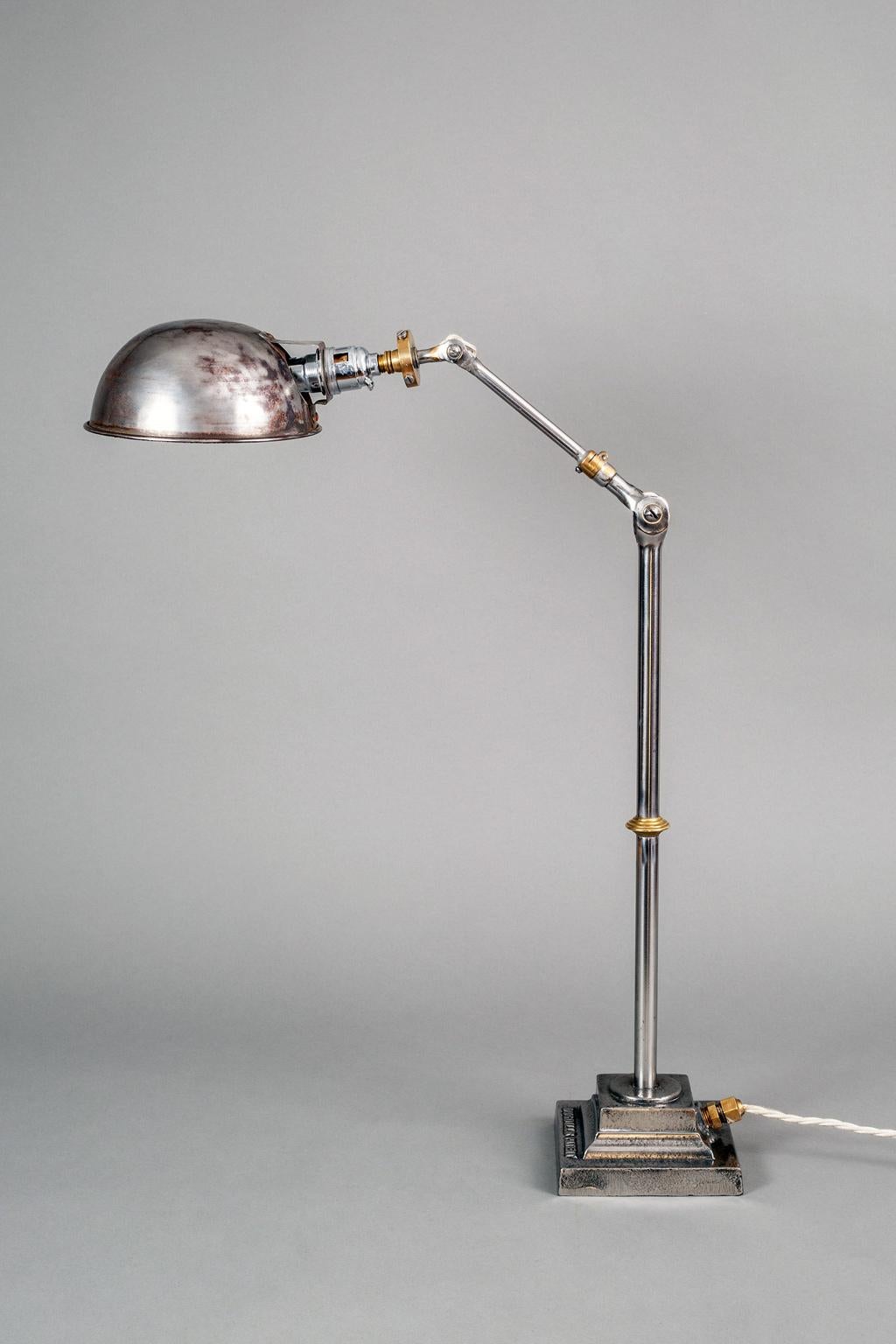 Steel and brass English industrial style reticulated work desk lamp. It is marked Dugdills patent on the base. The height is adjustable from 19