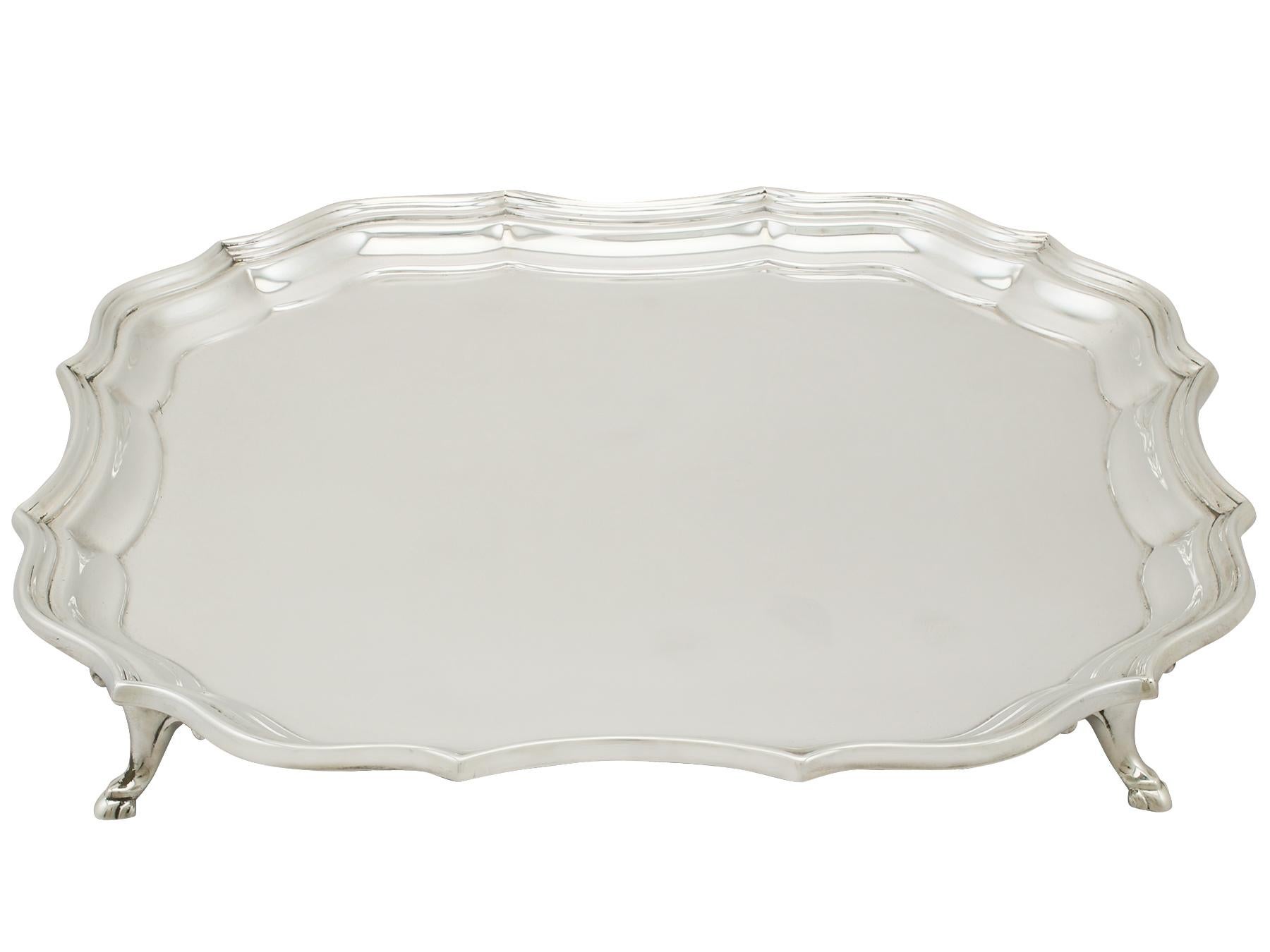 A fine and impressive vintage Elizabeth II English sterling silver salver; an addition to our silver dining collection.

This fine vintage Elizabeth II English sterling silver salver has a square shaped form onto four feet.

The surface of this