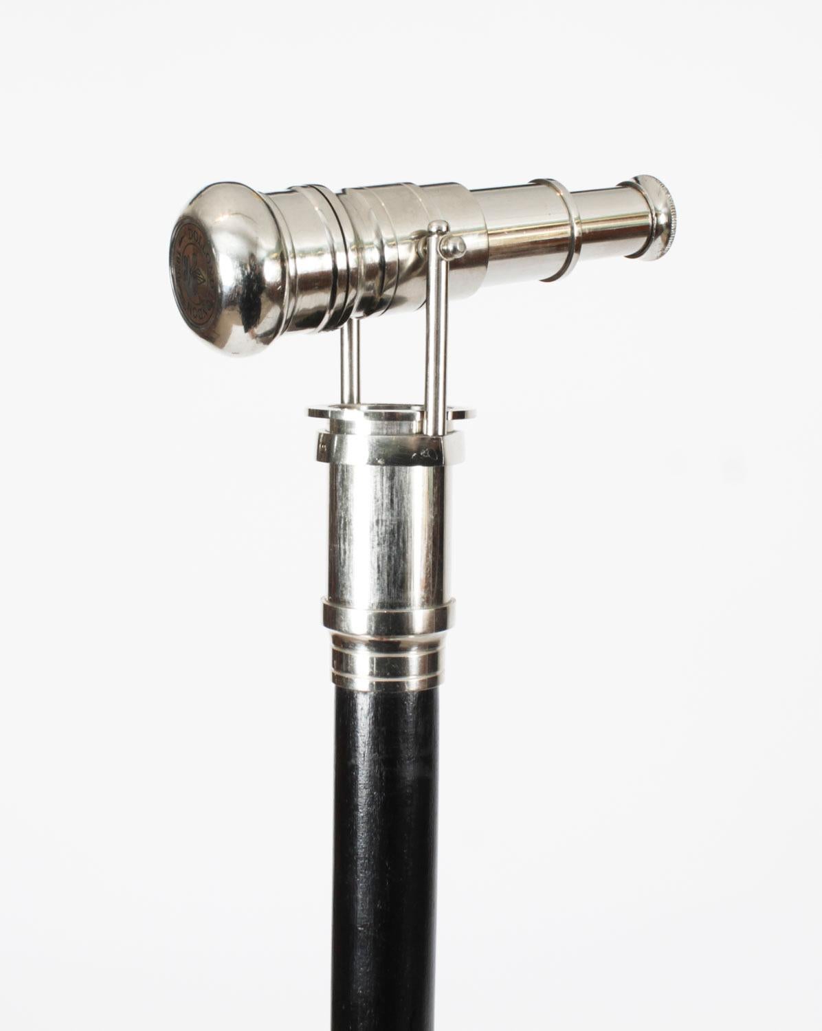 This is a beautiful vintage telescope walking stick by Dolland London, late 20th century in date.

The striking stick features a chrome cap unscrewing to reveal a small telescope with a blue lens on a  black lacquer hardwood shaft.

Add an