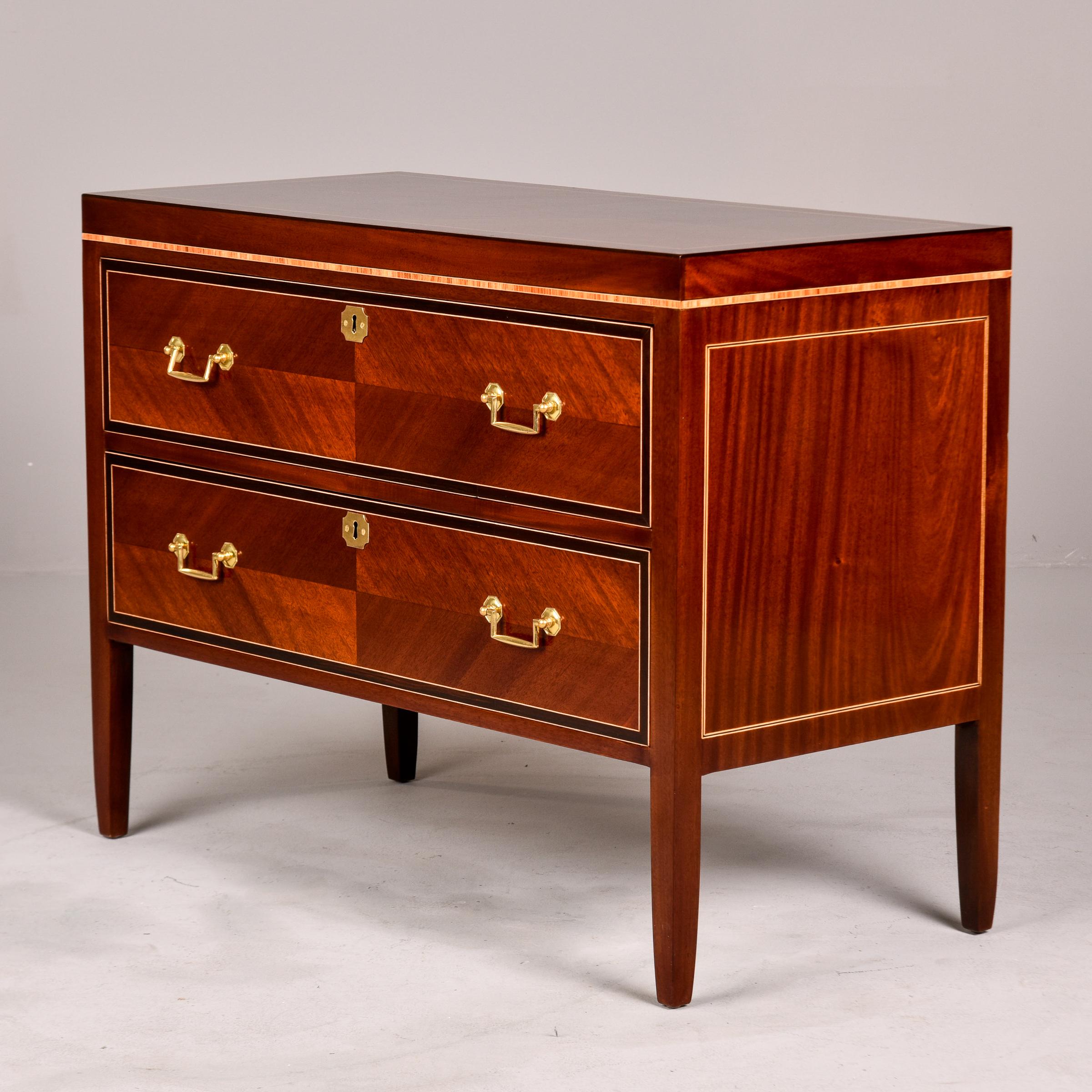 Circa 1930s English chest of two drawers has polished walnut veneer on the front, sides and top with contrasting maple and ebony details. Brass drawer pull hardware and escutcheons. Functional lock on drawers - one skeleton key included. Unknown