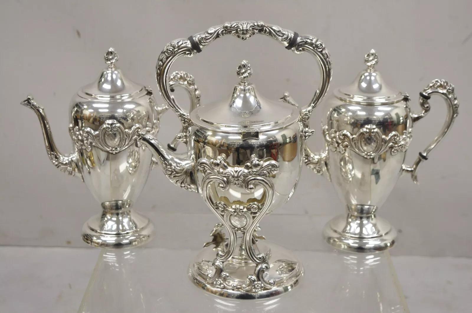 Vintage English Victorian Silver Plated Tea Set w/ Tilting Kettle - 6 Pc Set. Listing includes (1) tilting teapot on stand with warmer, (1) creamer, (1) twin handle sugar bowl, (1) sugar cube bowl, (2) coffee/ teapots. Circa Mid 20th Century.