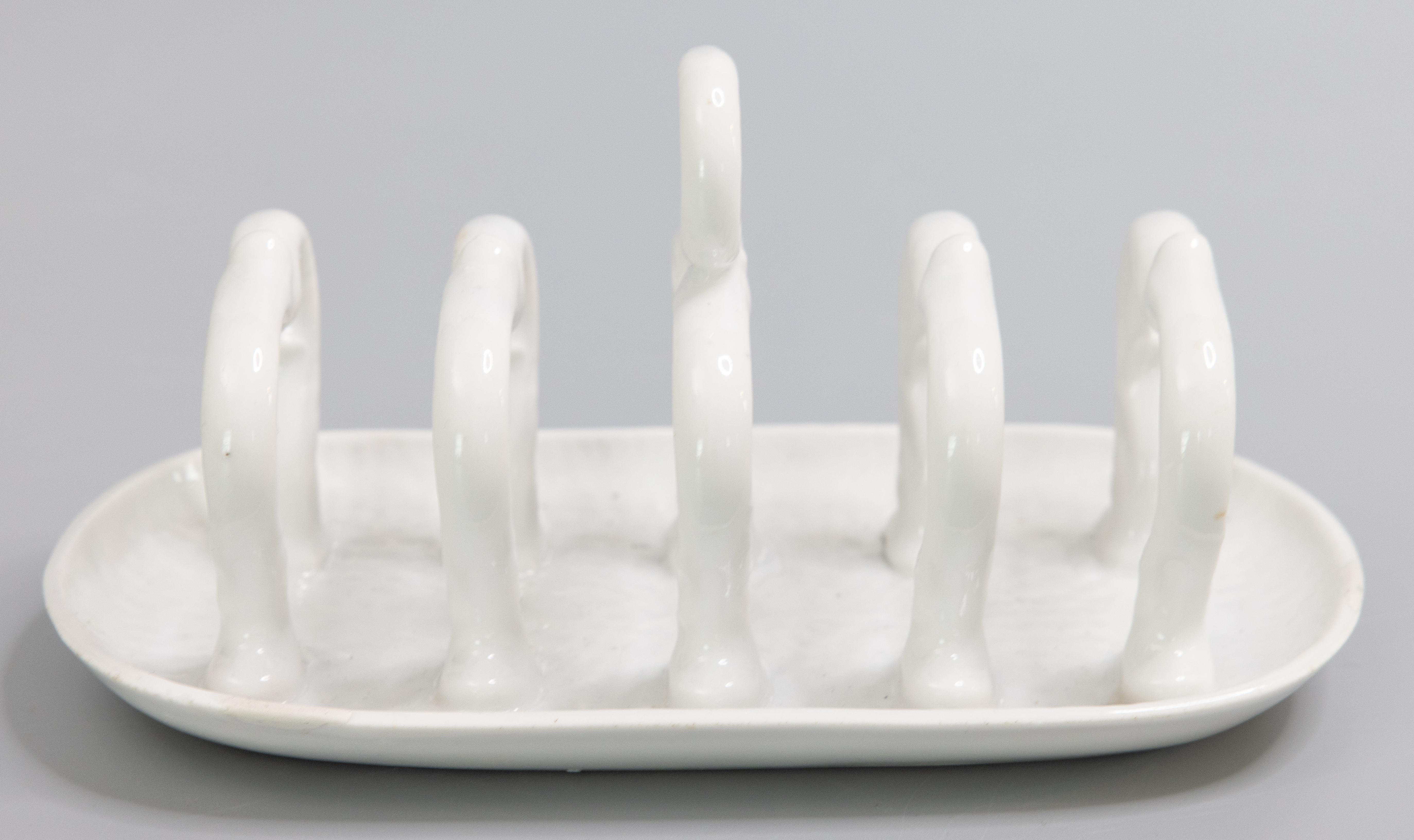 A lovely vintage English white white ironstone toast rack, circa 1950. No maker's mark. This charming toast rack has a beautiful design and would be wonderful for serving toast or could also be used as a letter holder.

Dimensions:
7.75