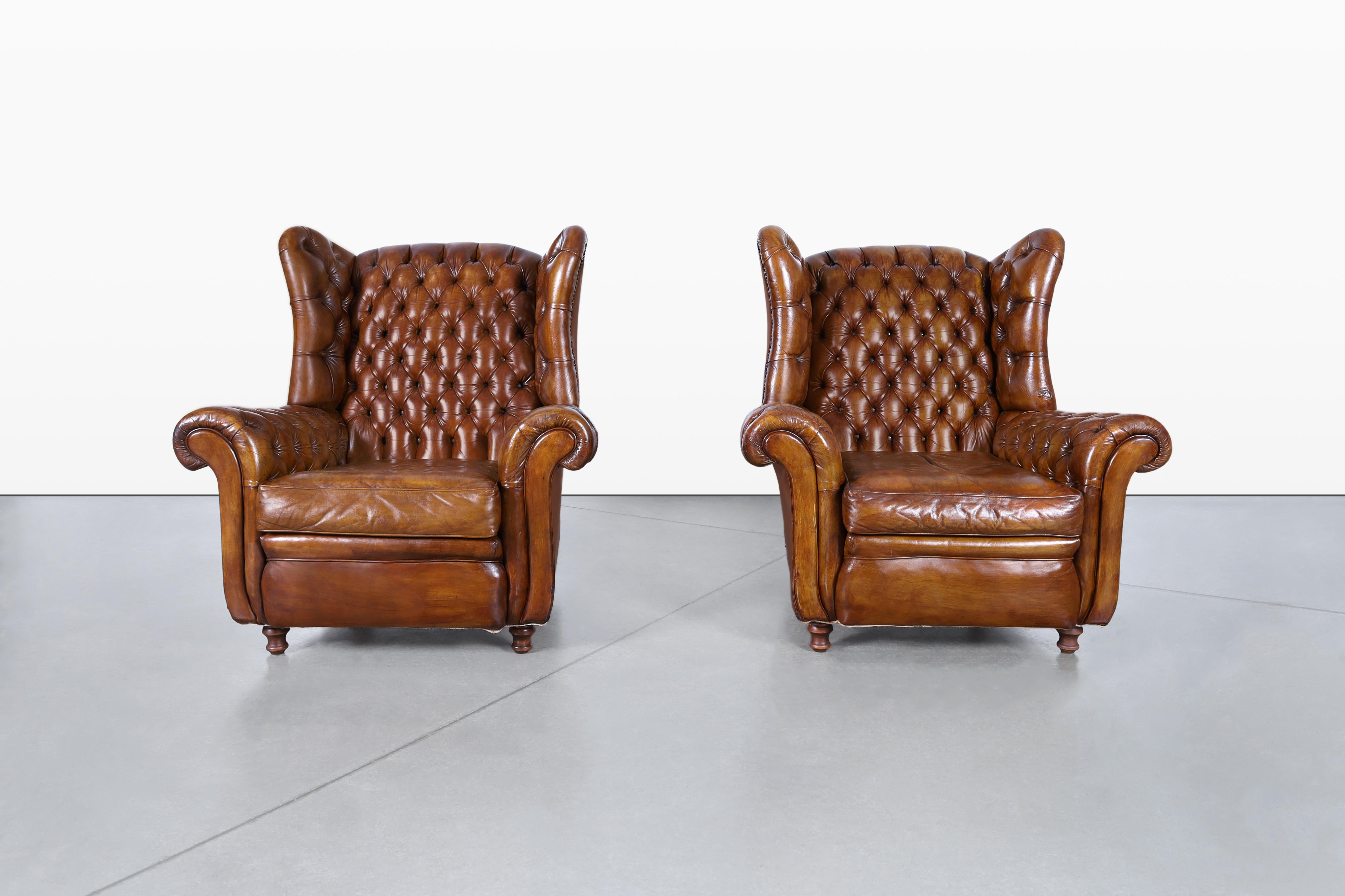 Wir präsentieren ein Paar exquisite Chesterfield-Loungesessel aus Leder, die Mitte des 20. Jahrhunderts in Großbritannien hergestellt wurden. Diese Stühle sind ein atemberaubendes Zeugnis klassischer britischer Handwerkskunst und zeigen ein