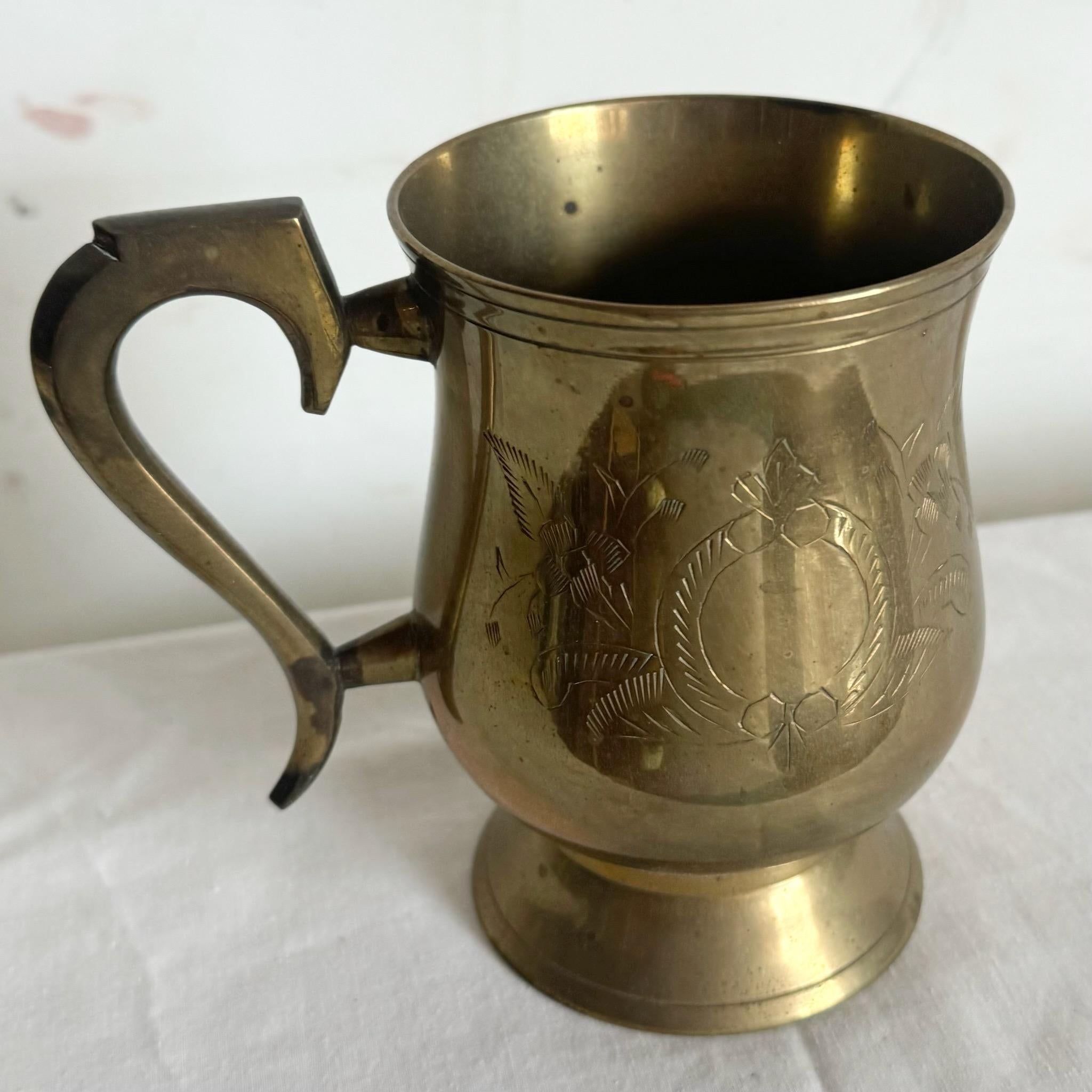 Add a touch of timeless elegance to your collection with this vintage engraved brass mug. Featuring intricate engravings and a rich brass finish, this beautifully crafted piece can be used as a functional mug or as a decorative accent. Perfect for