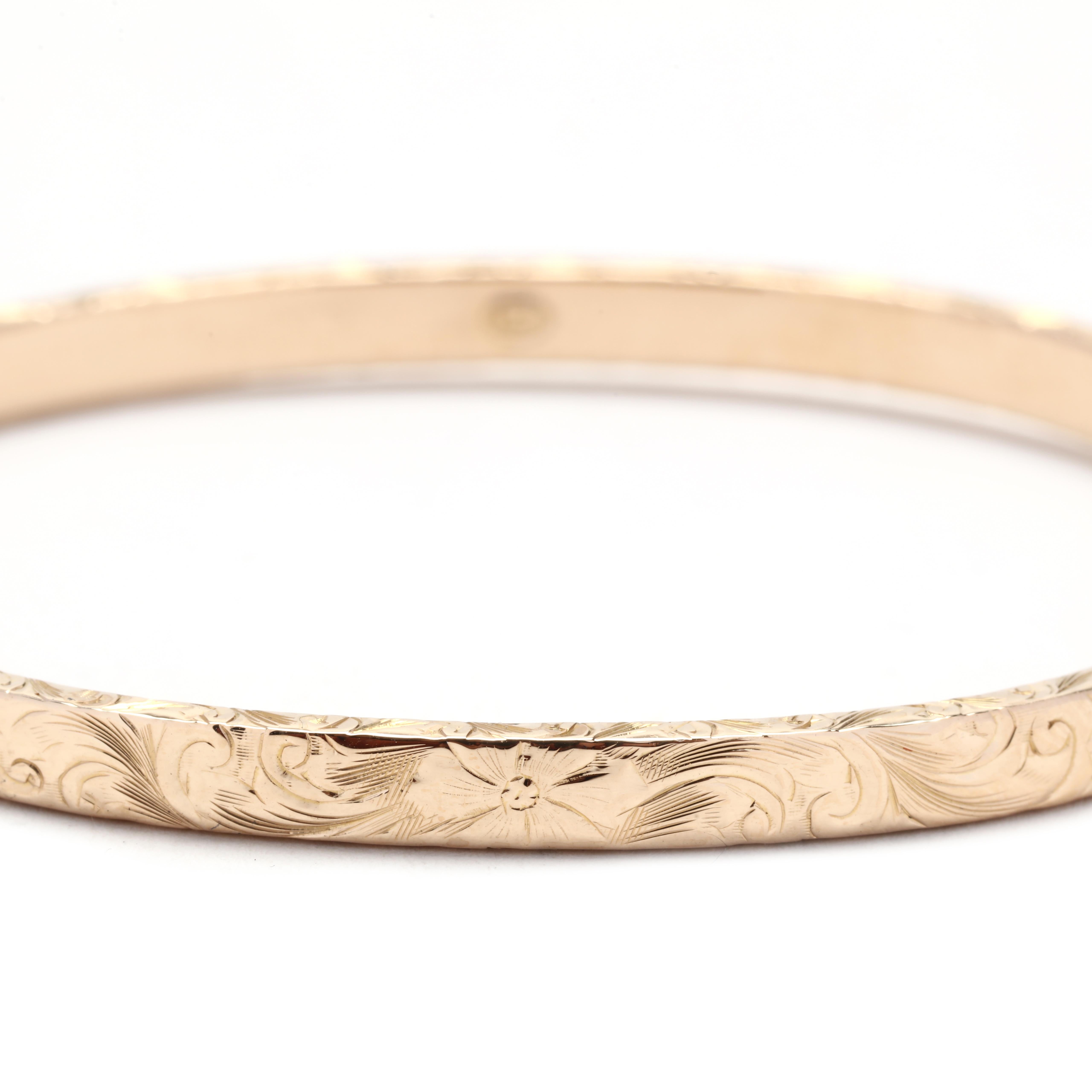 This vintage engraved hinged bangle bracelet is crafted in 14K yellow gold, making it a classic and timeless accessory. The bracelet measures 7 inches in length, making it the perfect fit for most wrists. Its thin and stackable design allows you to