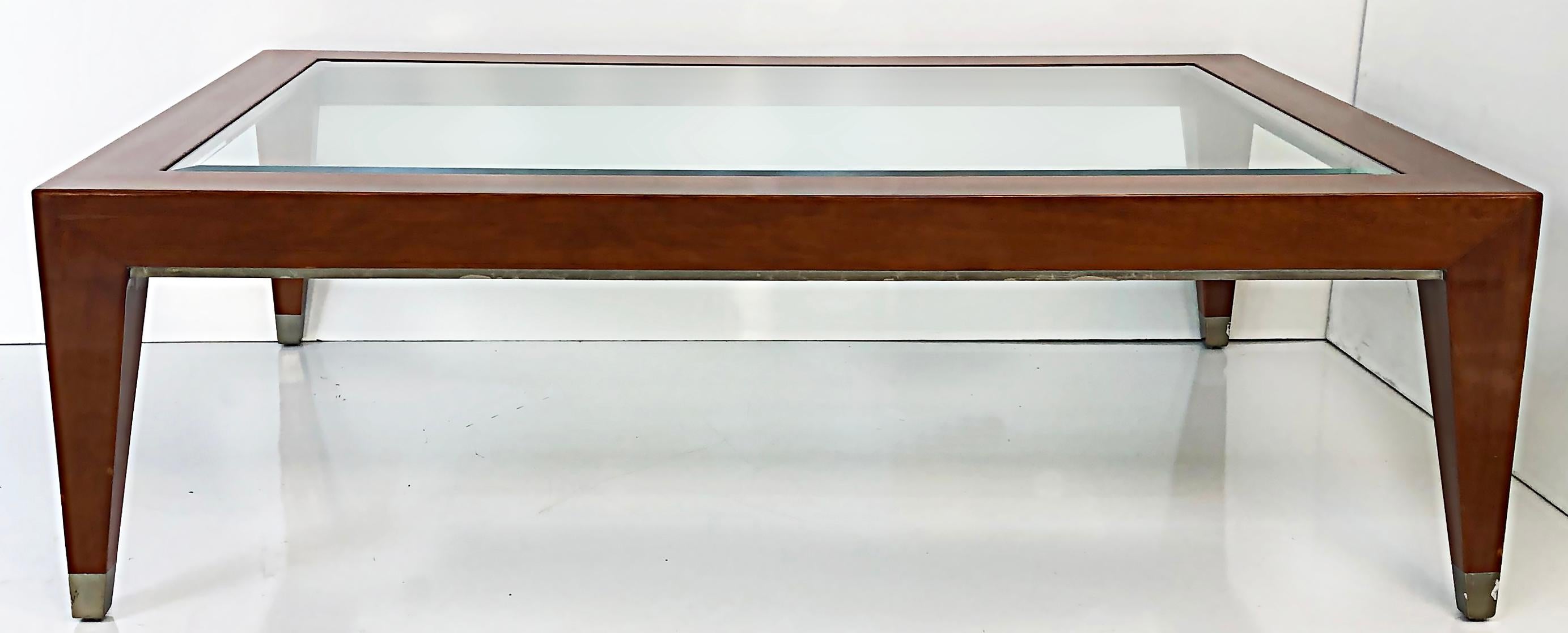 Vintage Enrique Garcel Mahogany Coffee Table with Inset Beveled Glass Top 

Offered for sale is a mahogany coffee table with an inset beveled glass top and silver leaf accents to the caps of the feet.  The table has an Enrique Garcel manufactur's