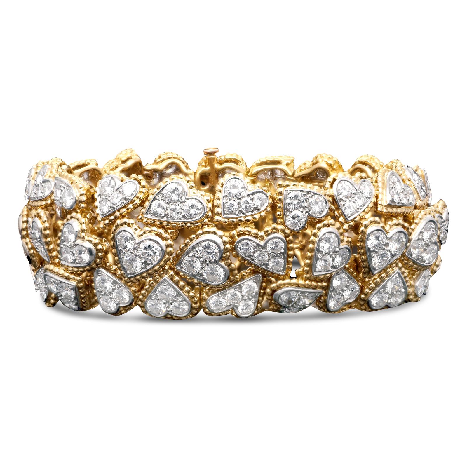 A magnificent 'Entwined diamond hearts' bracelet by Van Cleef & Arpels c.1965, designed as three rows of highly articulated overlapping asymmetric heart motifs in varying orientations with 18ct yellow gold beaded borders, all pavé set with round