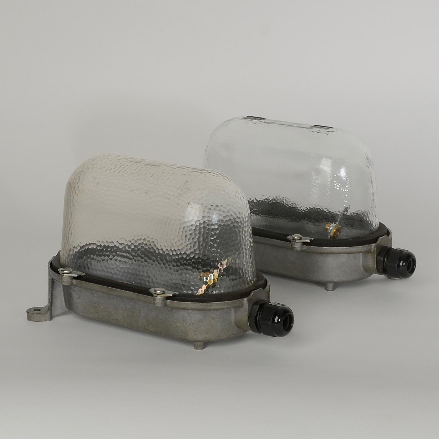 Vintage bulkhead wall lights salvaged from an industrial building in Eastern Germany. Manufactured by EOW in the communist period.

Deep-profile bubbled glass domes mounted on cast-aluminium wall housings that bear the makers mark. IP54 rated.