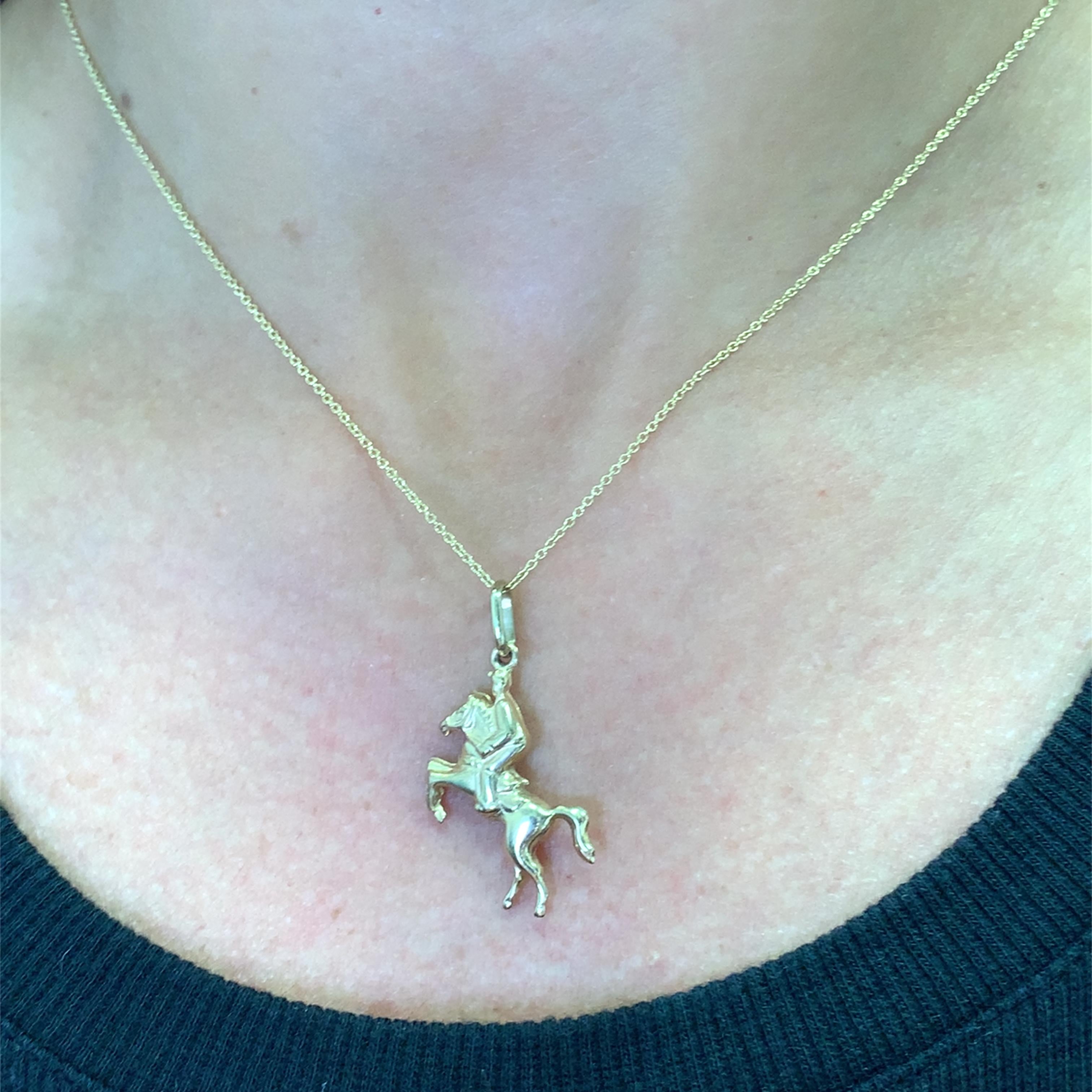 Zeigen Sie zeitlose Eleganz mit diesem exquisiten Goldanhänger, der ein fein detailliertes Pferd mit Reiter zeigt. Das glänzende Gold strahlt Wärme und Raffinesse aus und verleiht jedem Ensemble einen Hauch von reiterlichem Charme. Ein
