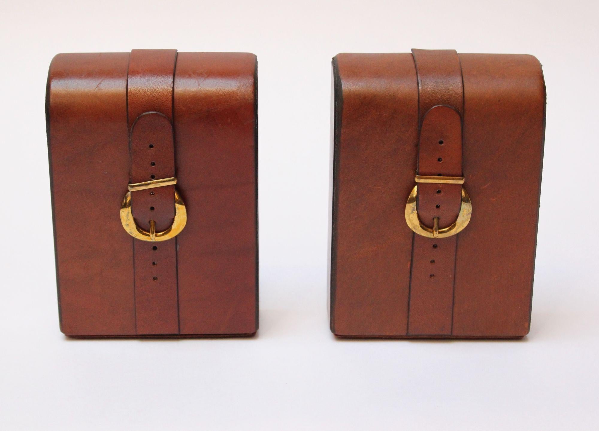Handsome saddle leather bookends with strap and brass buckle details and felted bases. Warm patina/light scuffs present consistent with age/use.
Measures: H: 6.63