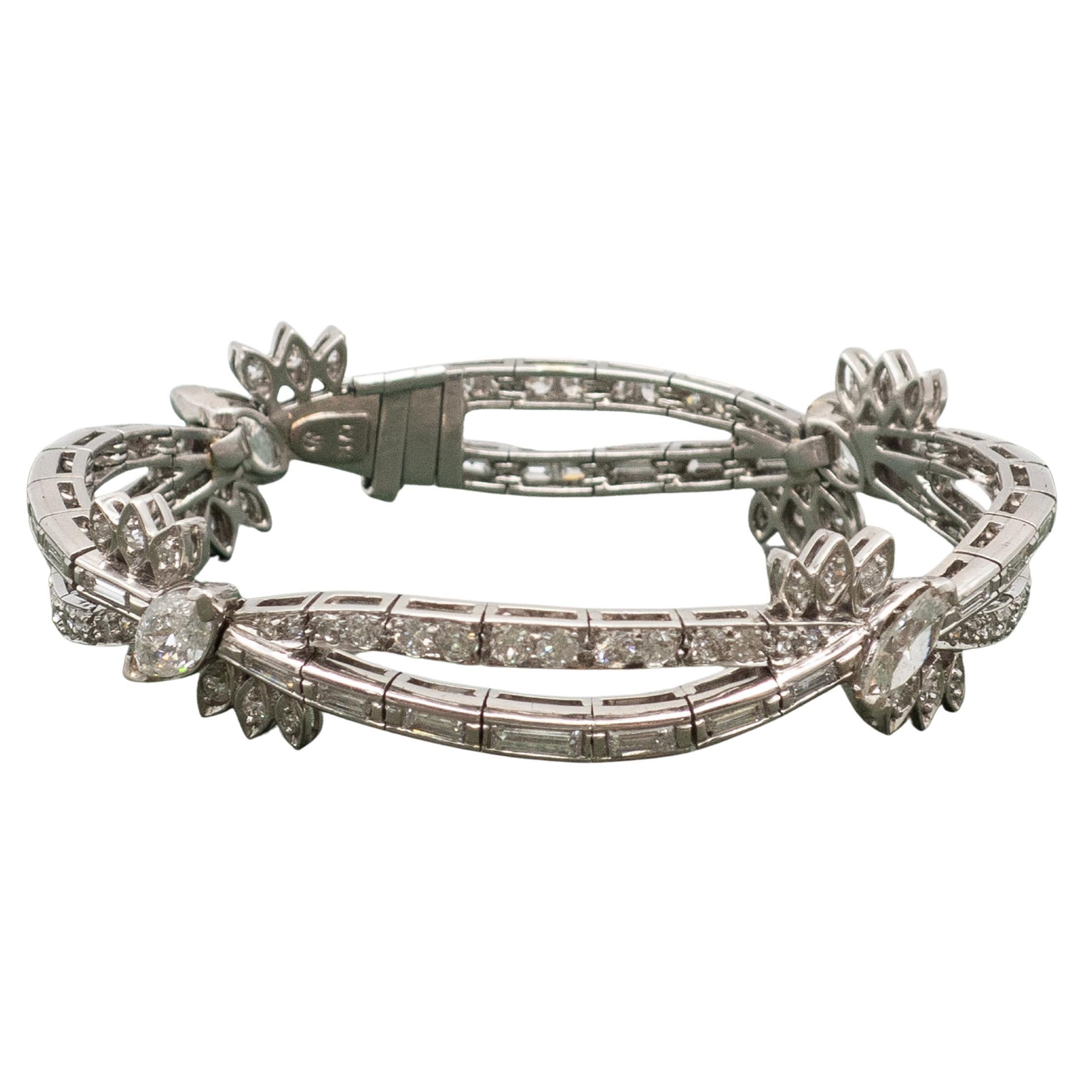 1950er Jahre ER Platin-Diamantenarmband. Florales Kreuzdesign, besetzt mit hochwertigen Diamanten in runder Brillant-, Baguette- und Marquiseform. Diamanten Gewicht ungefähre insgesamt 7,10 Karat in F-G-H Farbe & VS-SI Klarheit.

Der geschwungene