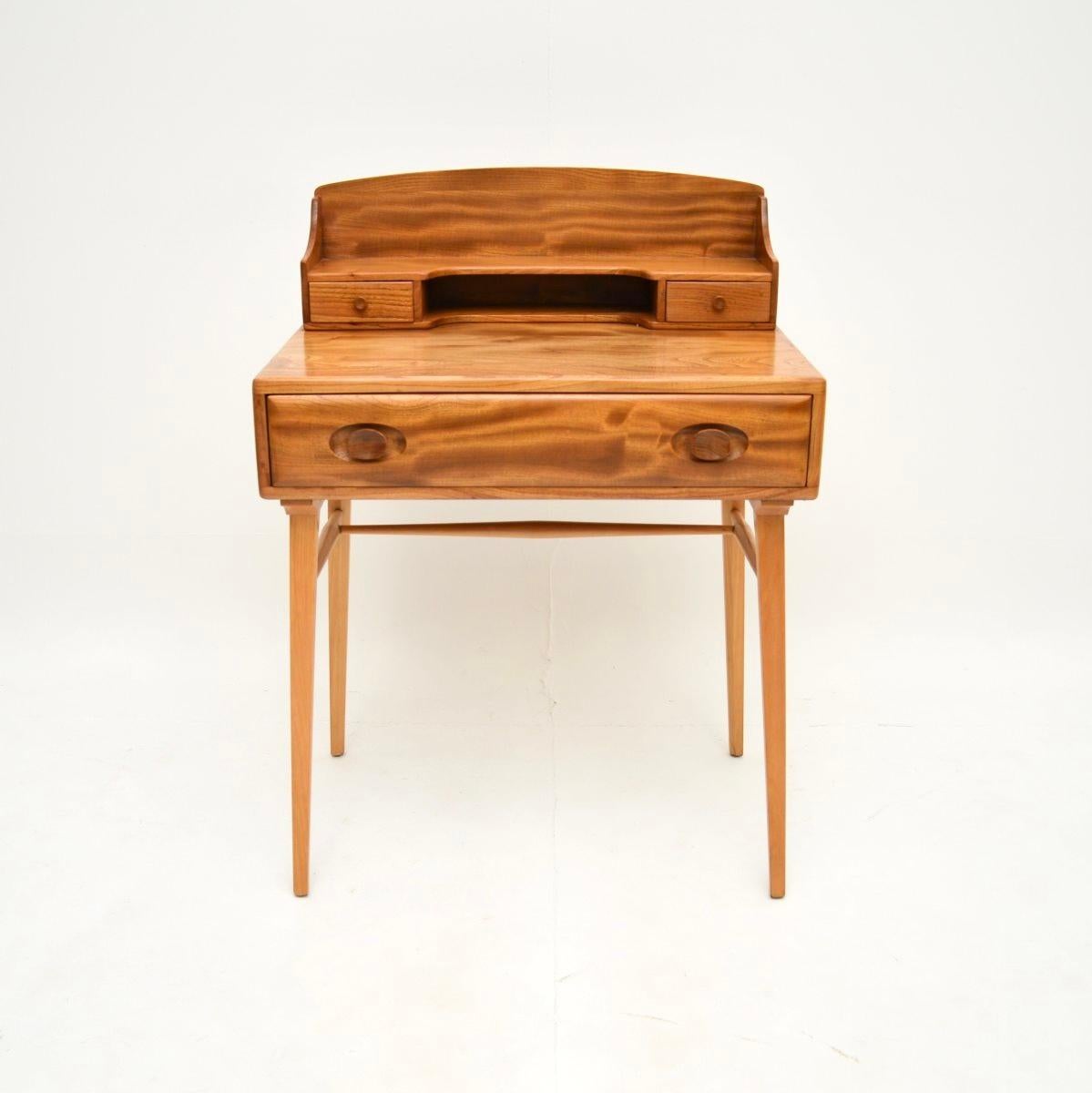 Ein schöner und sehr gut gemachter Vintage Ercol Schreibtisch aus massivem Ulmenholz. Es wurde in England hergestellt und stammt aus den 1960er Jahren.

Wie bei allen Produkten von Ercol ist die Qualität hervorragend. Es ist wunderschön gestaltet