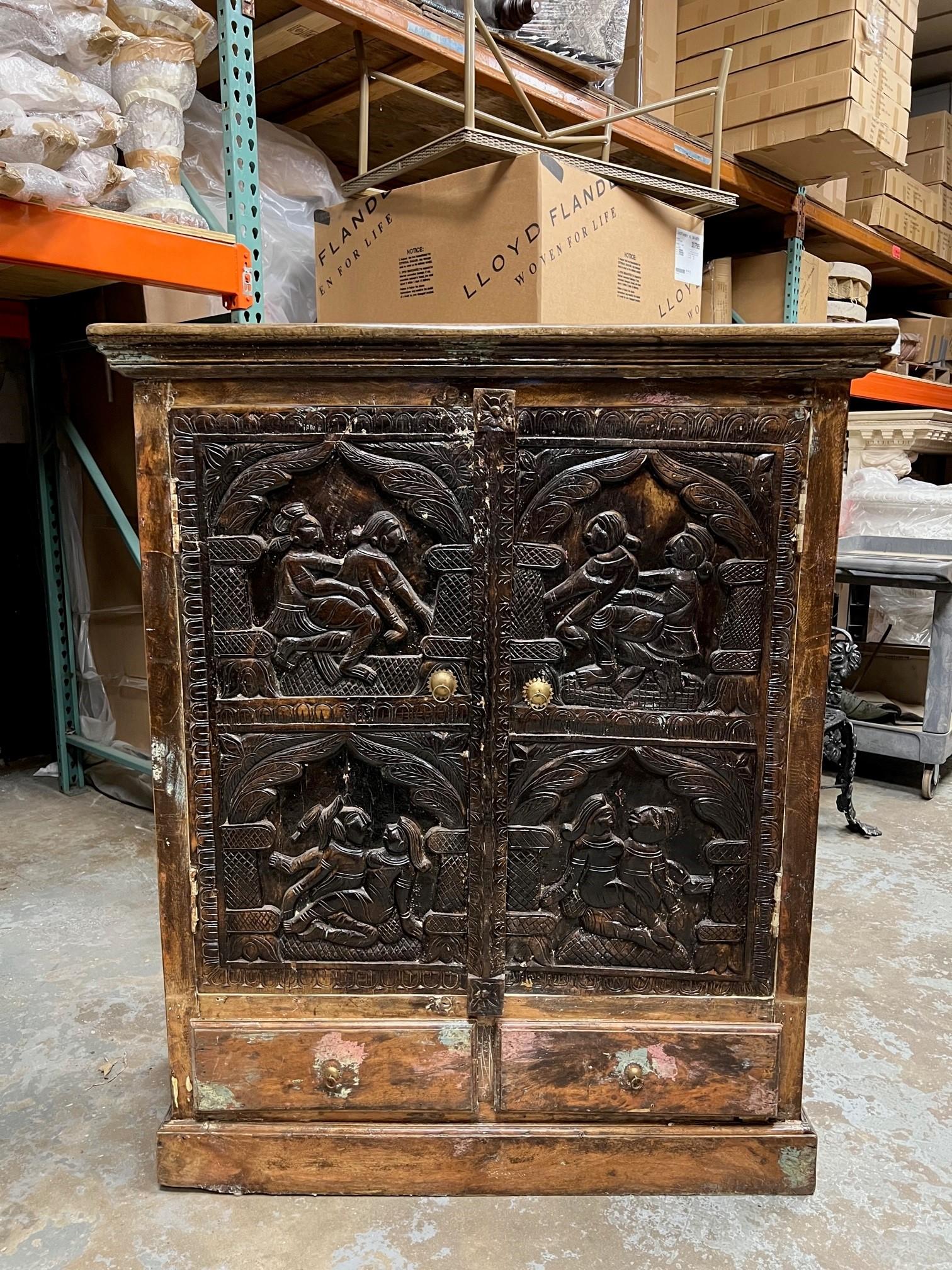 Vintage Erotic two door, two drawer carved wood cabinet imported from India. Each carved wood panel shows a different sex position. I believe the panels are older than the cabinet and the cabinet was built around the doors. It is an unusual piece, I