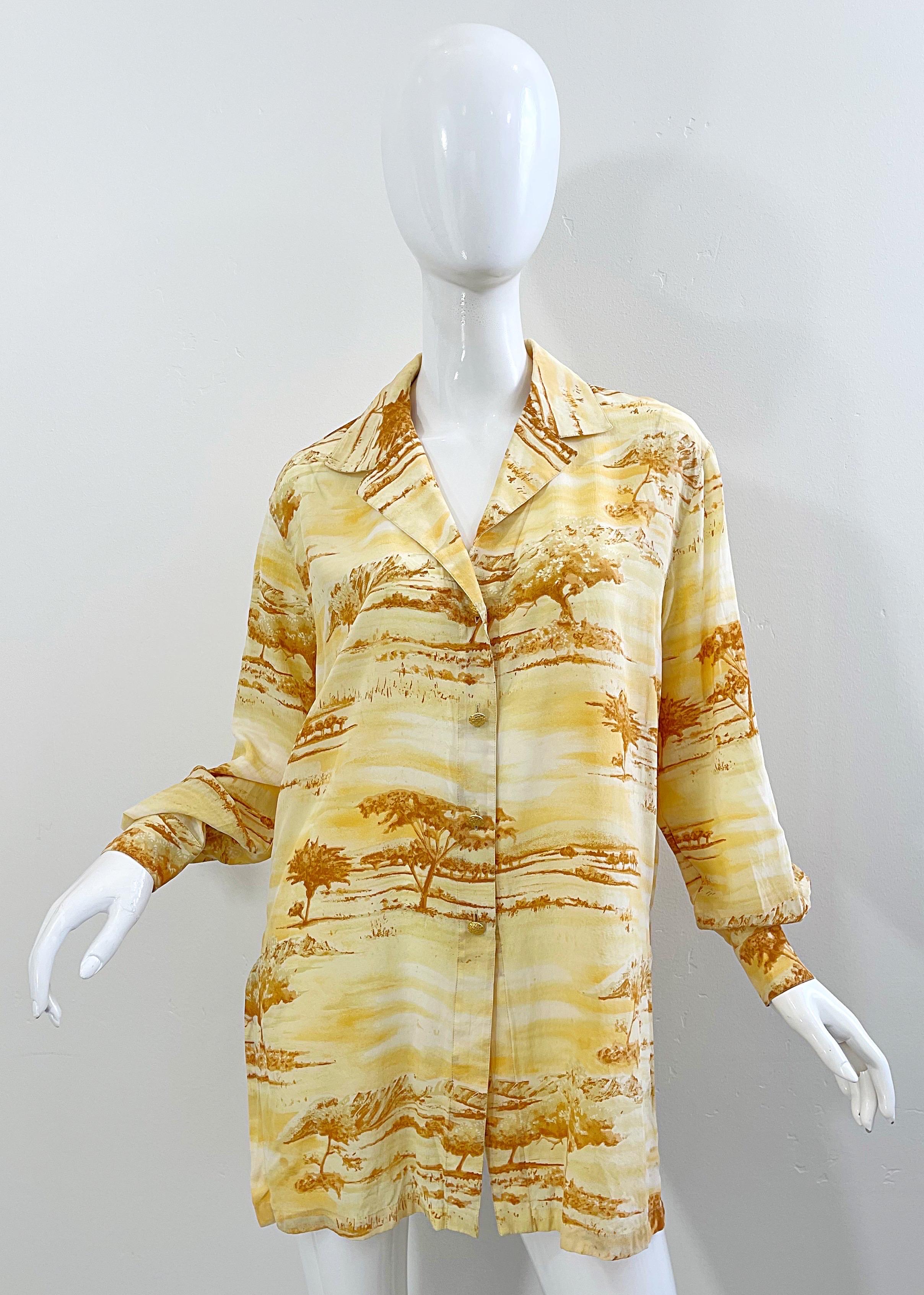 Safari chic dans cette blouse en soie à manches longues ESCADA by Margaretha Ley du début des années 90 ! Il présente des teintes chaudes de jaune, d'orange et de brun. Boutons logo dorés sur le devant et au bord de chaque manche. Ventilations de