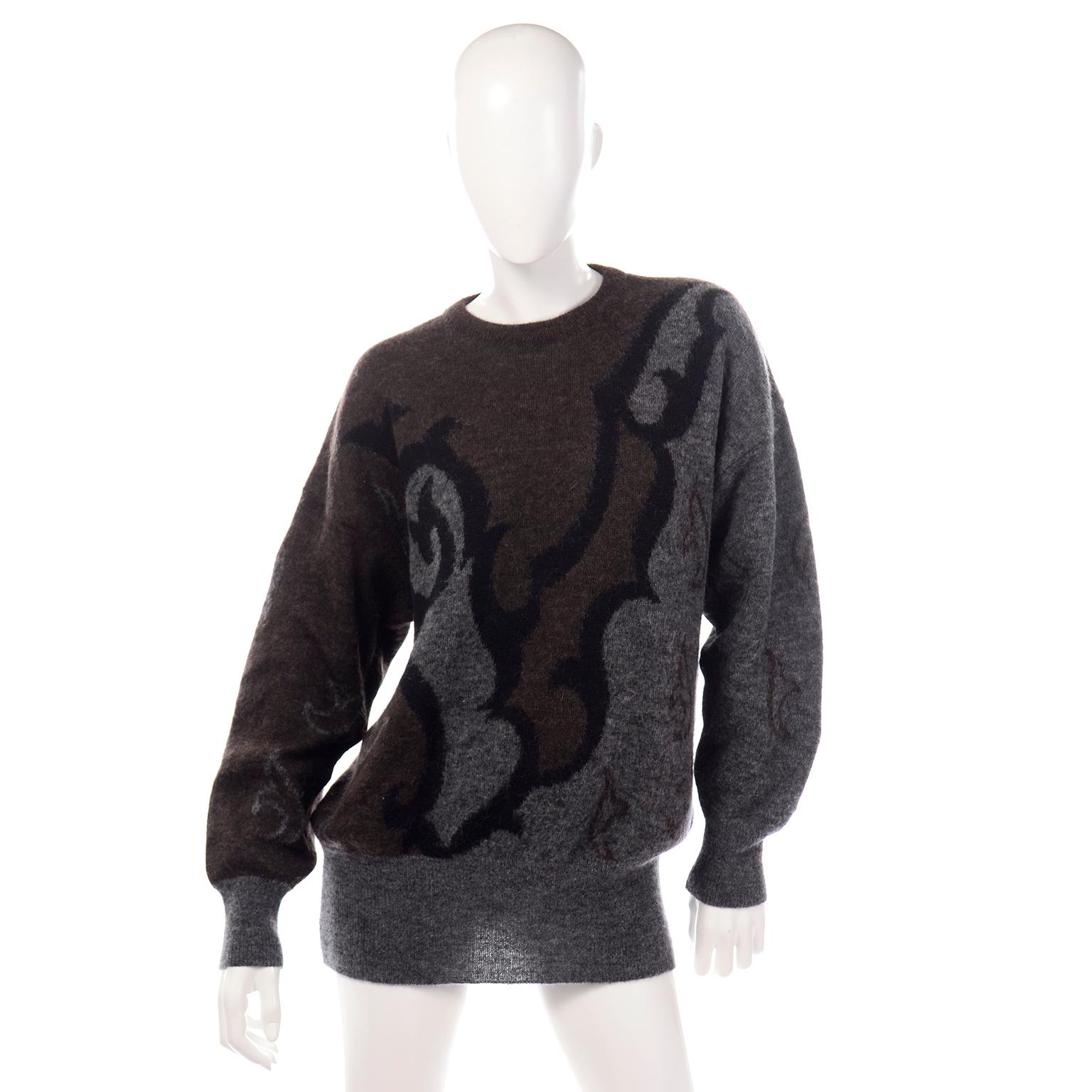 This is an amazing Escada sweater that was designed by Margaretha Ley in the 1980's. The sweater is oversized with lovely long slightly balloon style sleeves,  in a gray, black, and brown woven abstract print throughout. This sweater does not have a