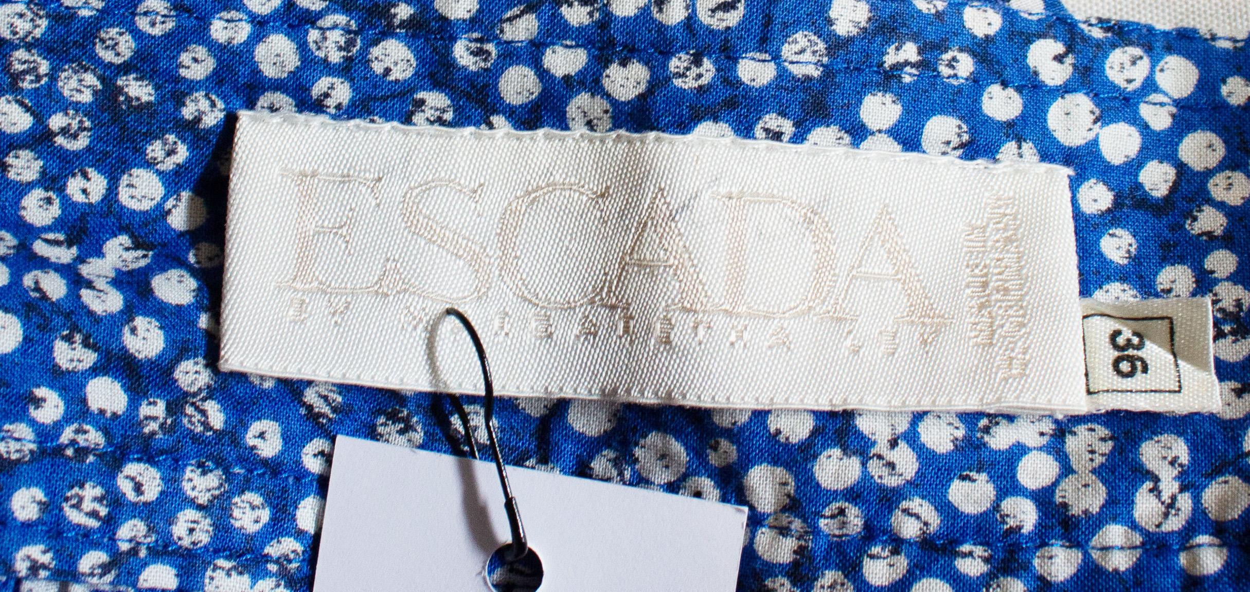 A fun vintage cotton skirt by Escada.  The skirt is in a blue and white cotton in an wonderful print, and has an interesting button opening at the front and back. There are two pockets, and the skirt is unlined. Measurements;  Waist 27''. length 35''