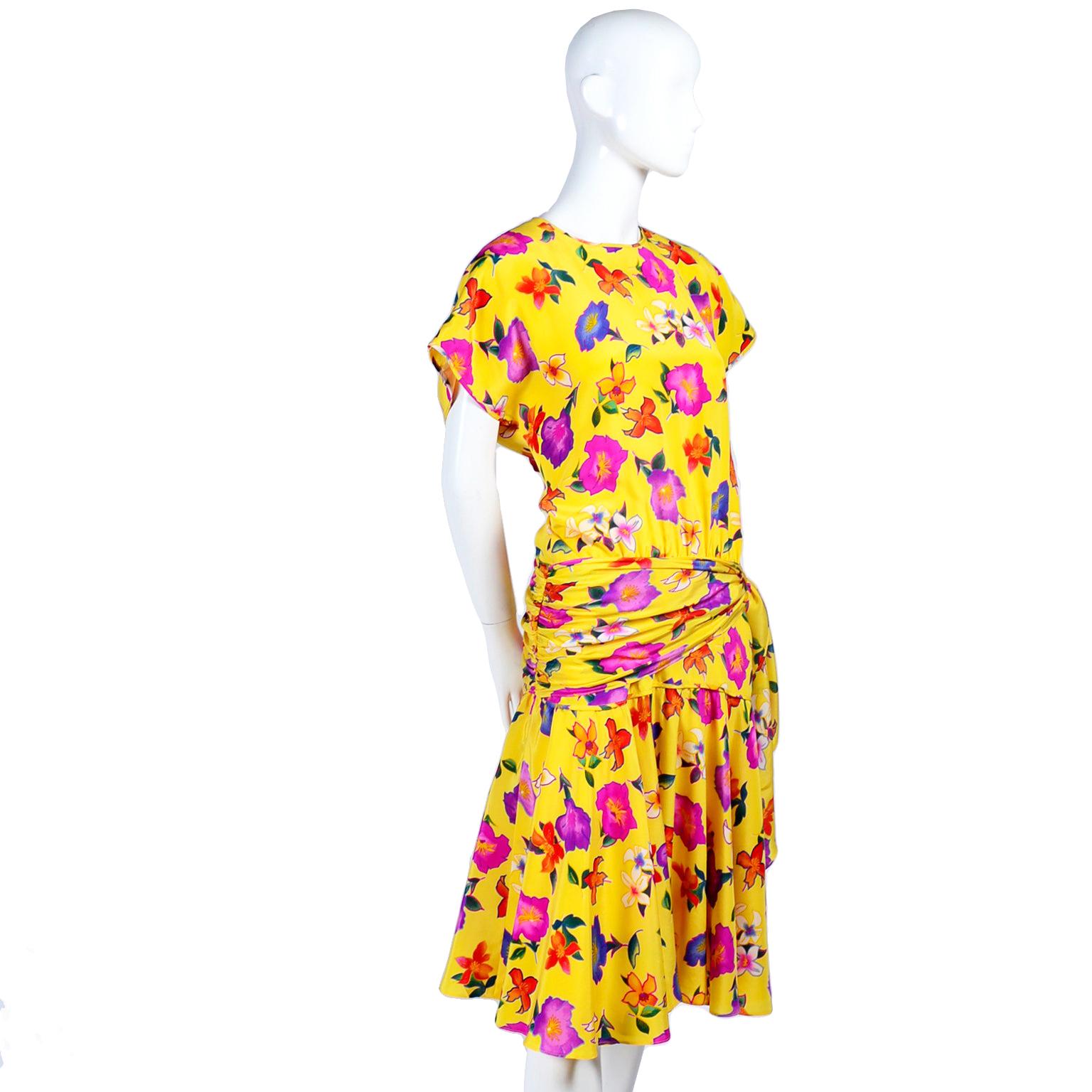 This is such a pretty Escada vintage dress,  in a rich yellow silk print with beautiful tropical flowers in shades of pink, fuchsia, blue, orange and purple. The dress has cap sleeves, a side zipper with buttons above, and buttons up the back. 
We
