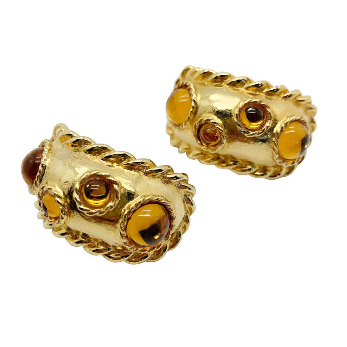 Statement vintage Escada huggie earrings. Featuring a large rope edged huggie set with cabochon glass stones.
Escada was first launched in Germany in 1976 by Wolfgang and Margaretha Ley. Their label standing for modern elegance, cool glamour and