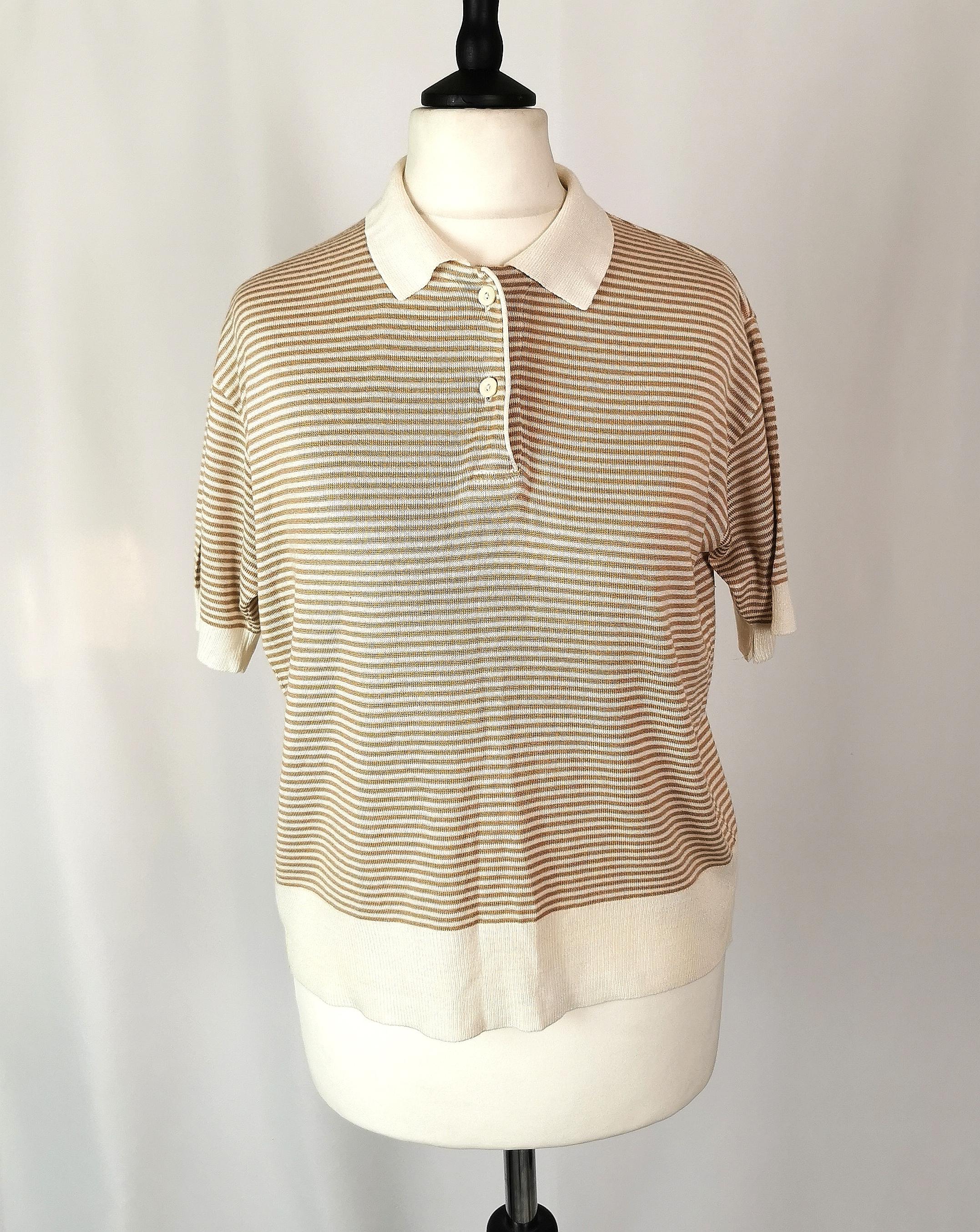 An original preppy favourite by Escada.

Vintage Escada ladies soft knit polo shirt / top.

Warm beige and soft cream stripe with a knitted waistband, cuffs and collar, the top buttons up at the neck just like a traditional polo shirt.

It is