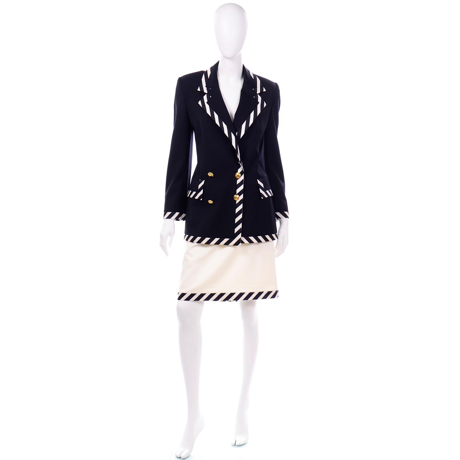 This is a beautiful black and white stripe Summer weight wool skirt suit designed by Margaretha Ley for Escada. The suit includes a black double breasted blazer with pretty gold buttons at the front opening and functional flap pockets. The shoulders