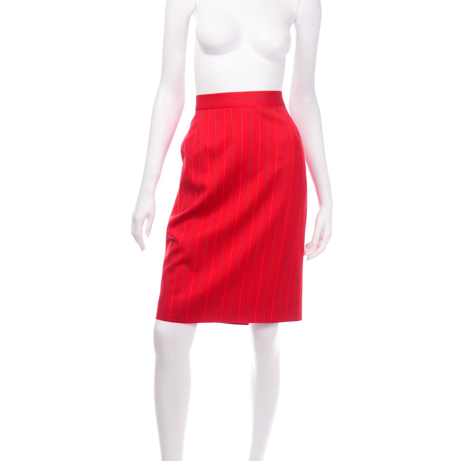 This vintage Escada Margaretha Ley pencil skirt is a beautiful red summer weight wool with pink and black vertical pinstripes. The narrow waistband has a back button and a metal zipper down the center back for closure. There is small kick pleat at